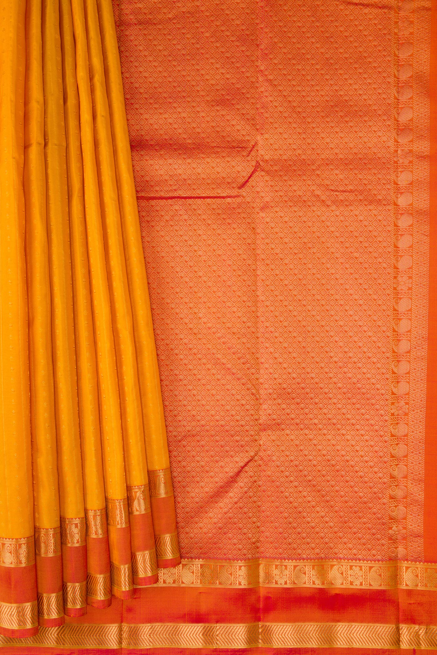 Pleats and pallu of Mustard Kanchipuram Silk Saree with Zari Butta on the body and Zari Border. 