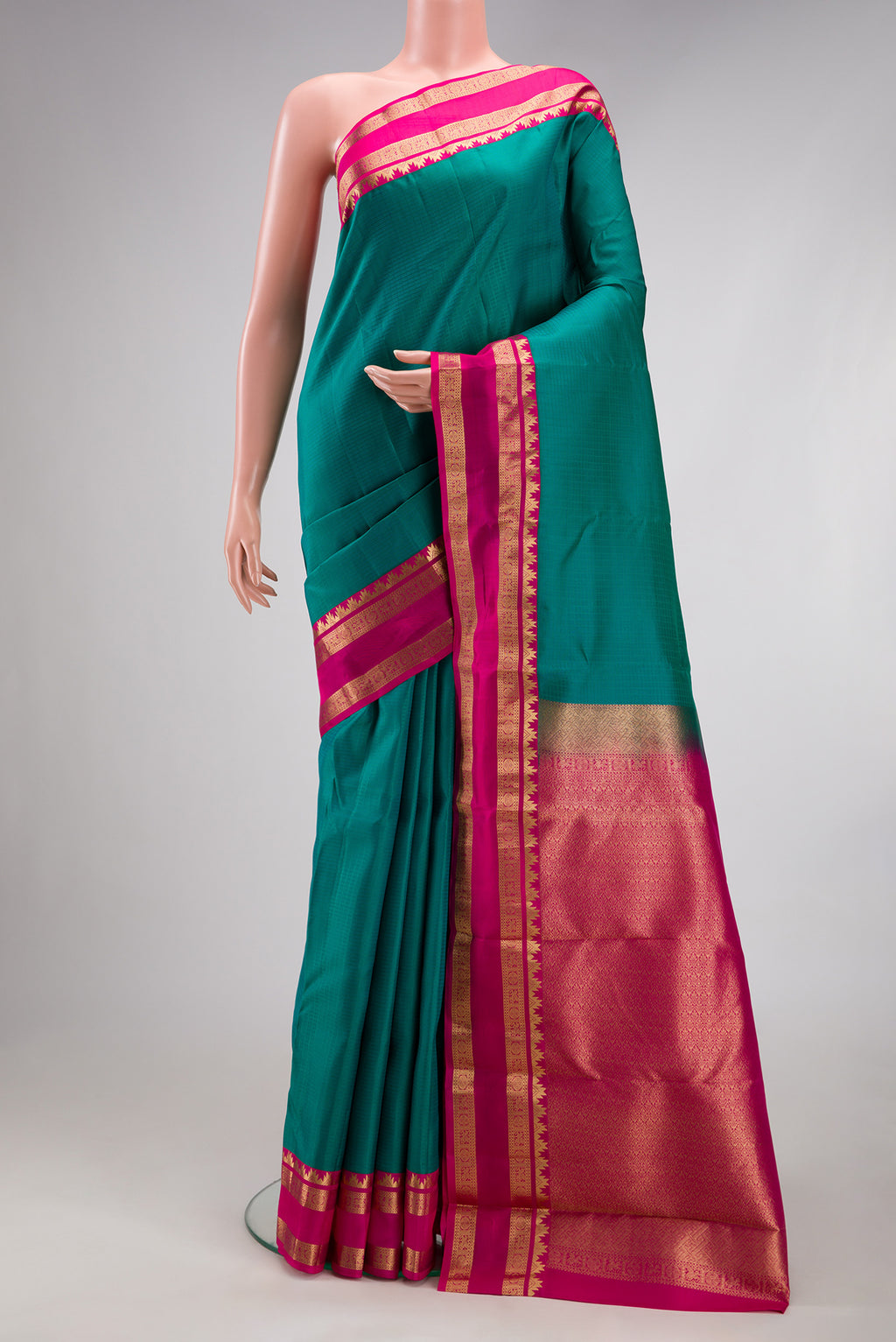 Green Kanchipuram Silk Saree with Checked design on the body and Zari Border.  displayed on a mannequin
