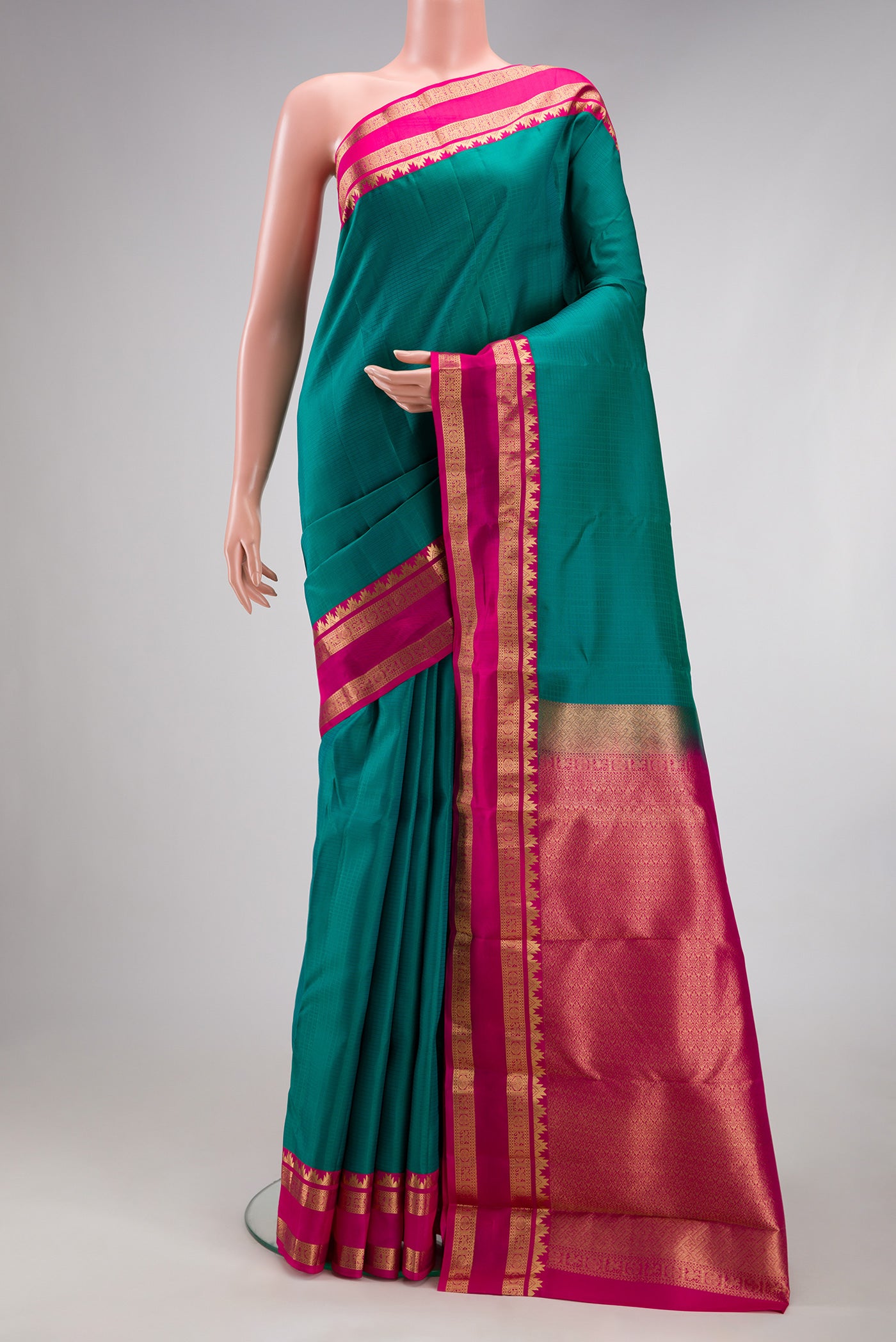 Green Kanchipuram Silk Saree with Checked design on the body and Zari Border.  displayed on a mannequin