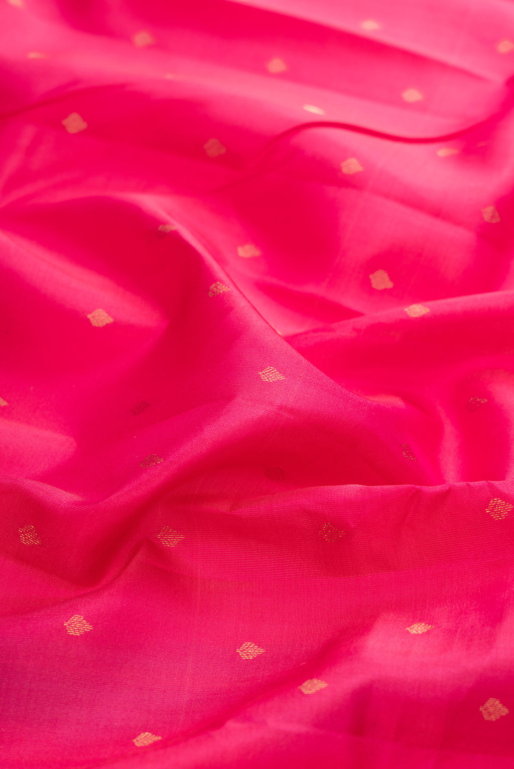 Close up of Dark Pink Kanchipuram Silk Saree with Zari Butta on the body and Zari Border.  displaying folds