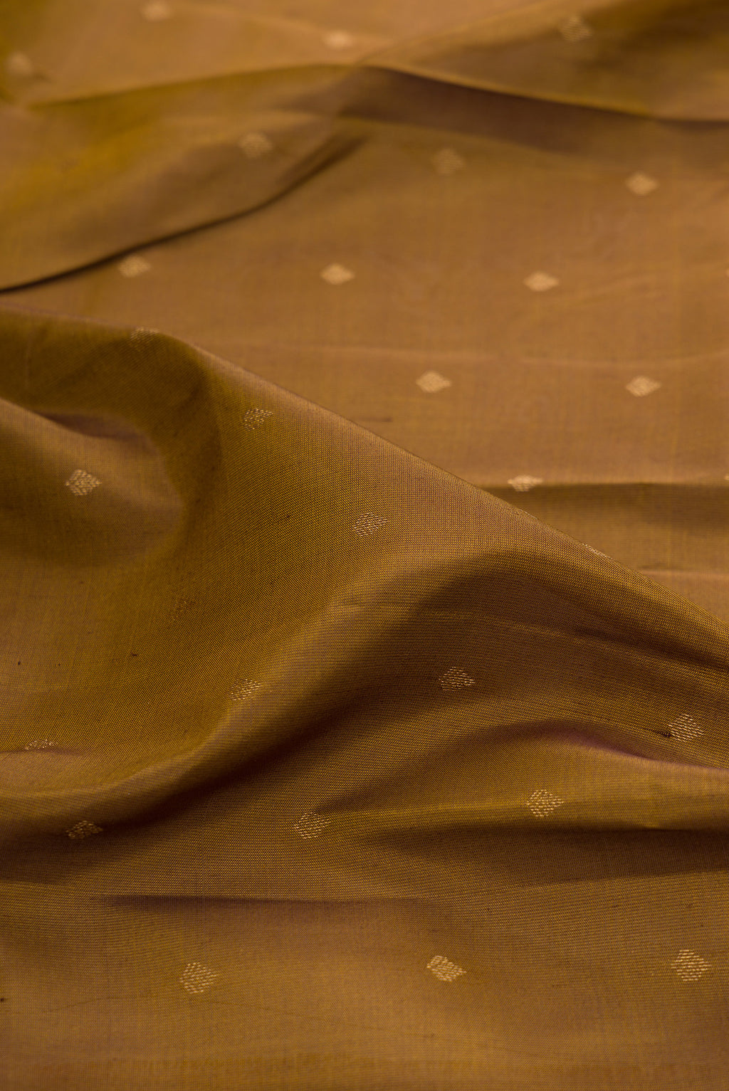 Close up of Mehandi Green Kanchipuram Silk Saree with Zari Butta on the body and Zari Border.  displaying folds