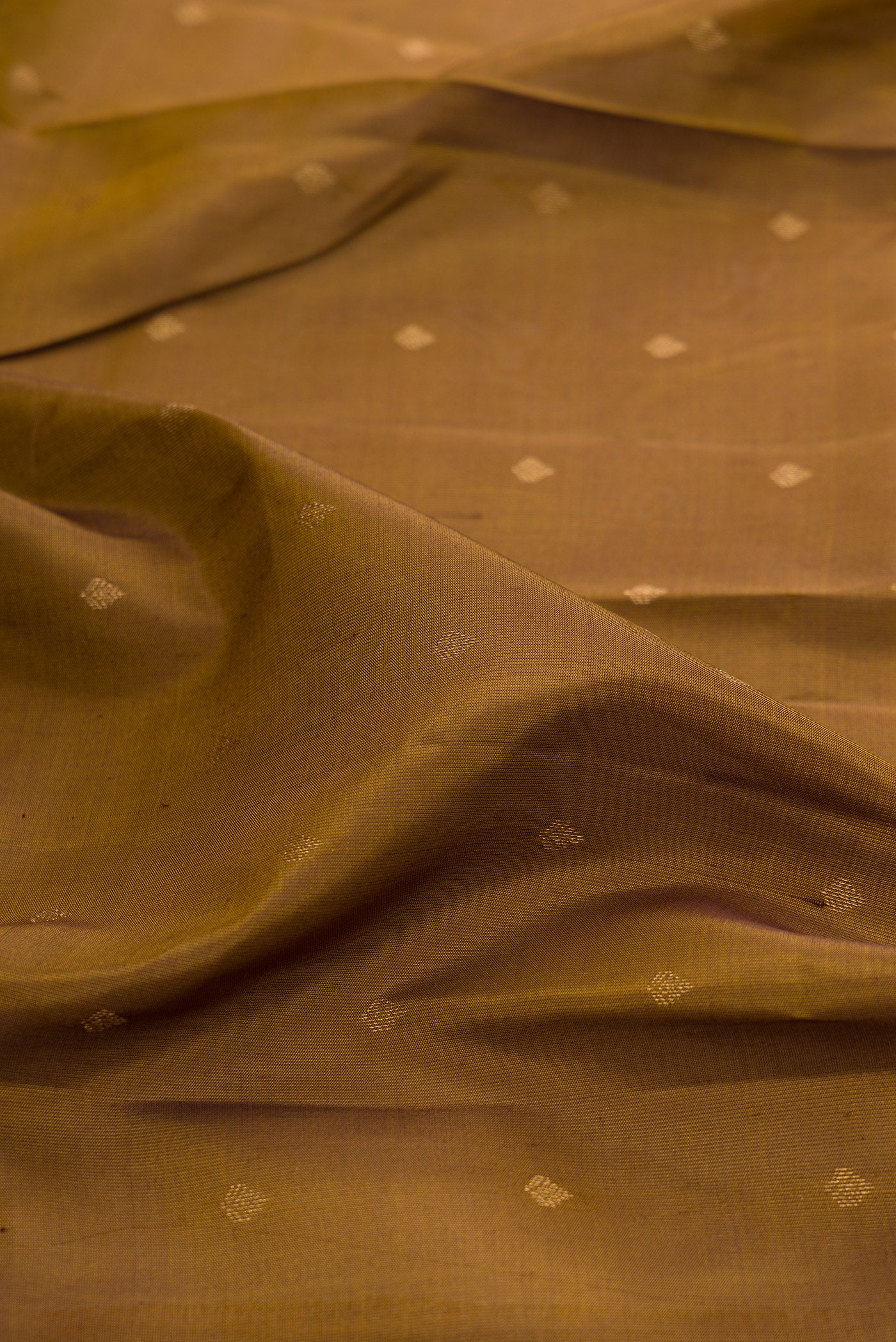 Close up of Mehandi Green Kanchipuram Silk Saree with Zari Butta on the body and Zari Border.  displaying folds