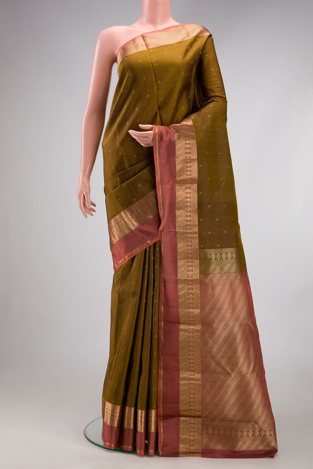 Mehandi Green Kanchipuram Silk Saree with Zari Butta on the body and Zari Border.  displayed on a mannequin
