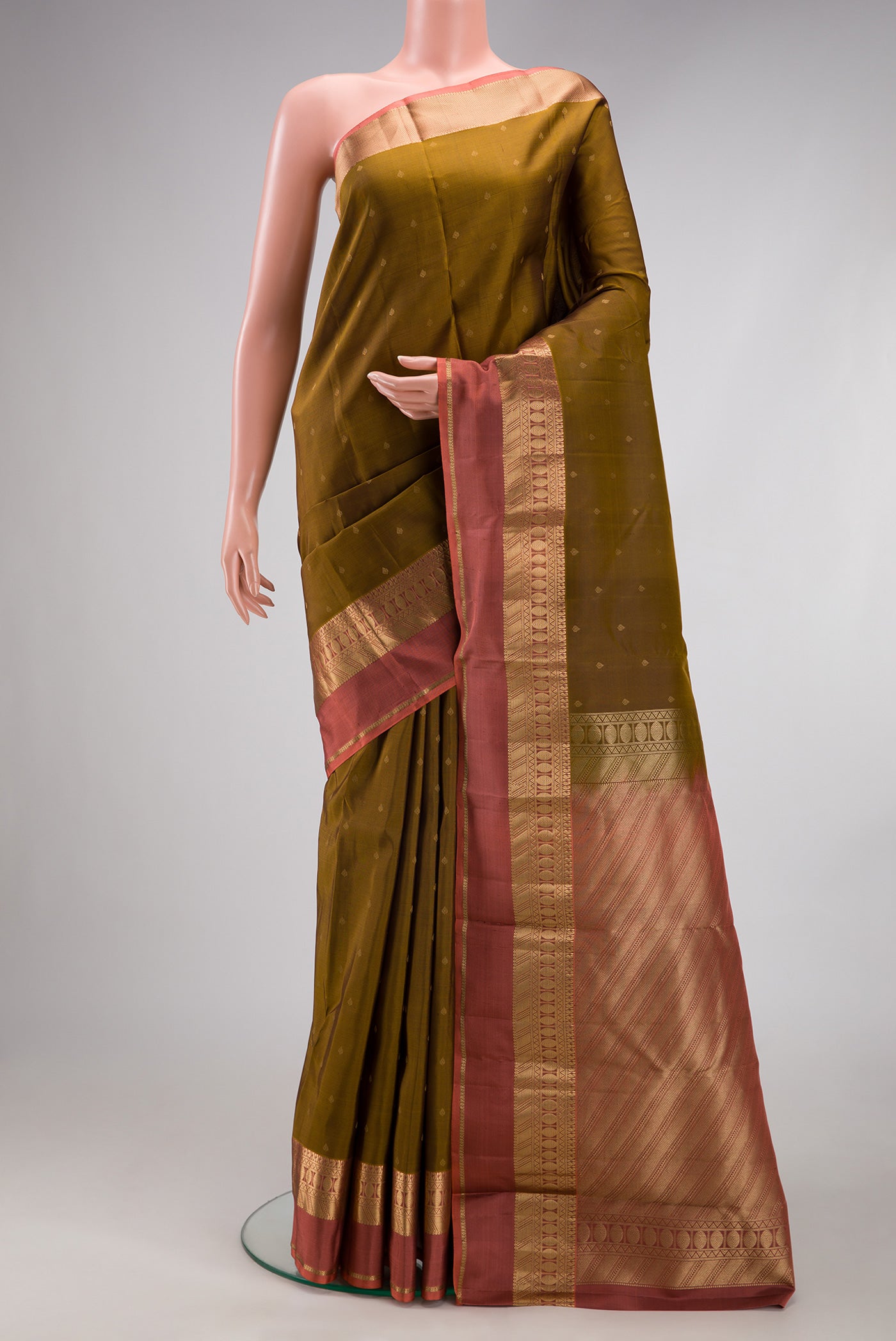 Mehandi Green Kanchipuram Silk Saree with Zari Butta on the body and Zari Border.  displayed on a mannequin