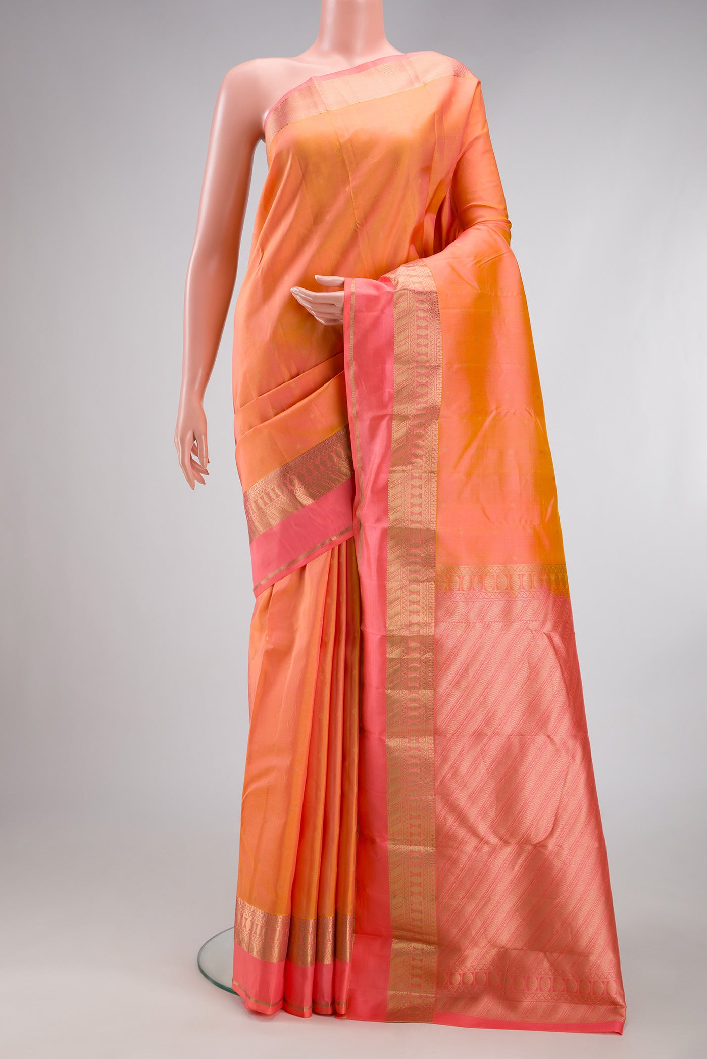 Golden Peach Kanchipuram Silk Saree with Zari Butta on the body and Fancy Border.  displayed on a mannequin