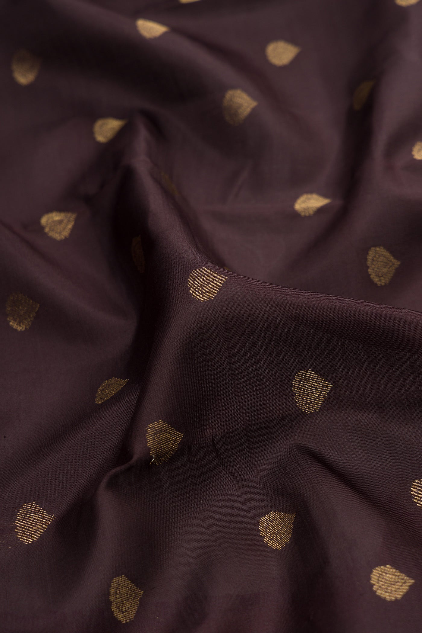 Close up of Coffee Brown Kanchipuram Silk Saree with Zari Butta on the body and Zari Border.  displaying folds