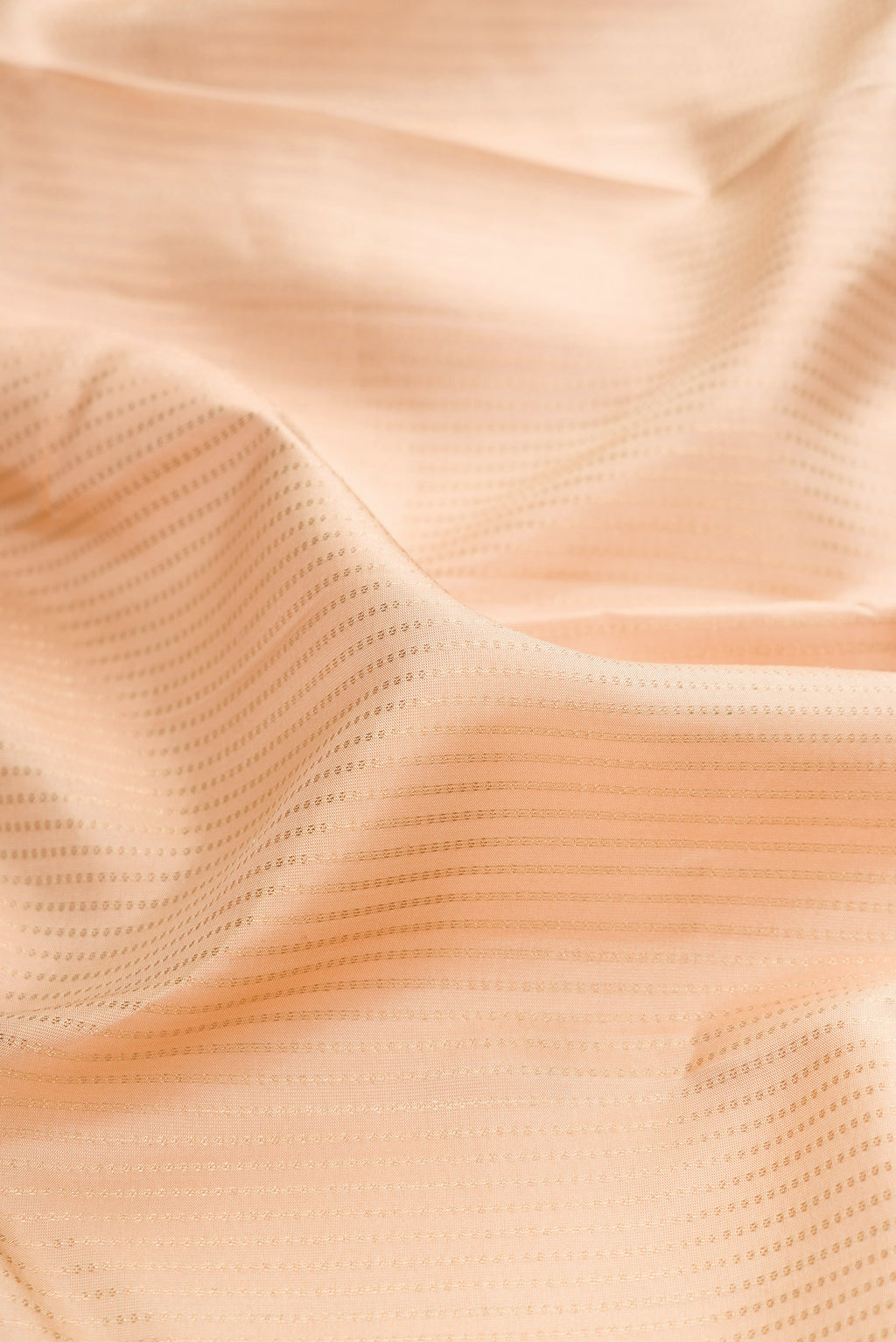 Close up of Cream Kanchipuram Silk Saree with Stripes on the body and Zari Border.  displaying folds