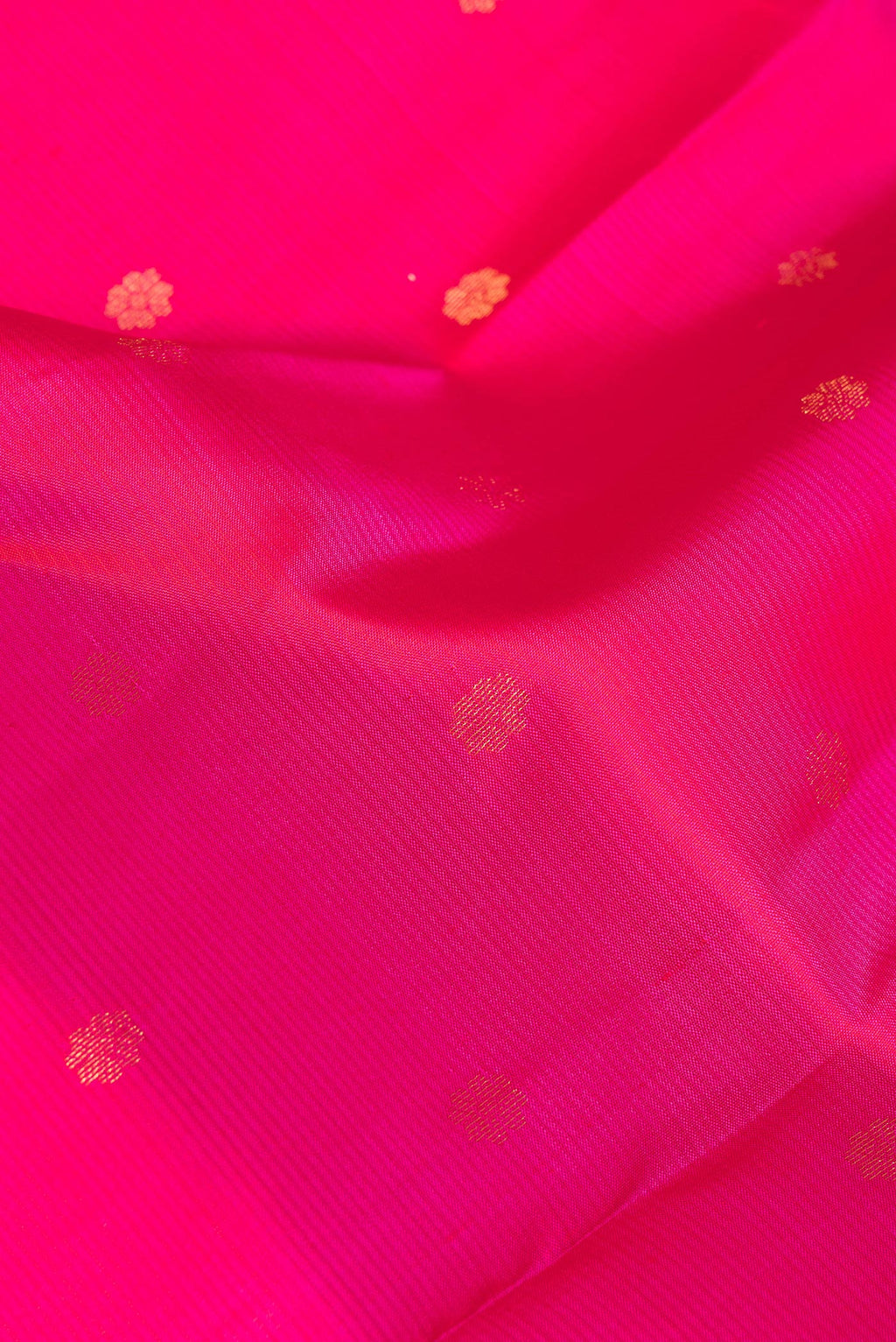 Close up of Pure Silk Dark Pink Kanchipuram Saree with Zari Butta on the body and Zari Border.  displaying folds