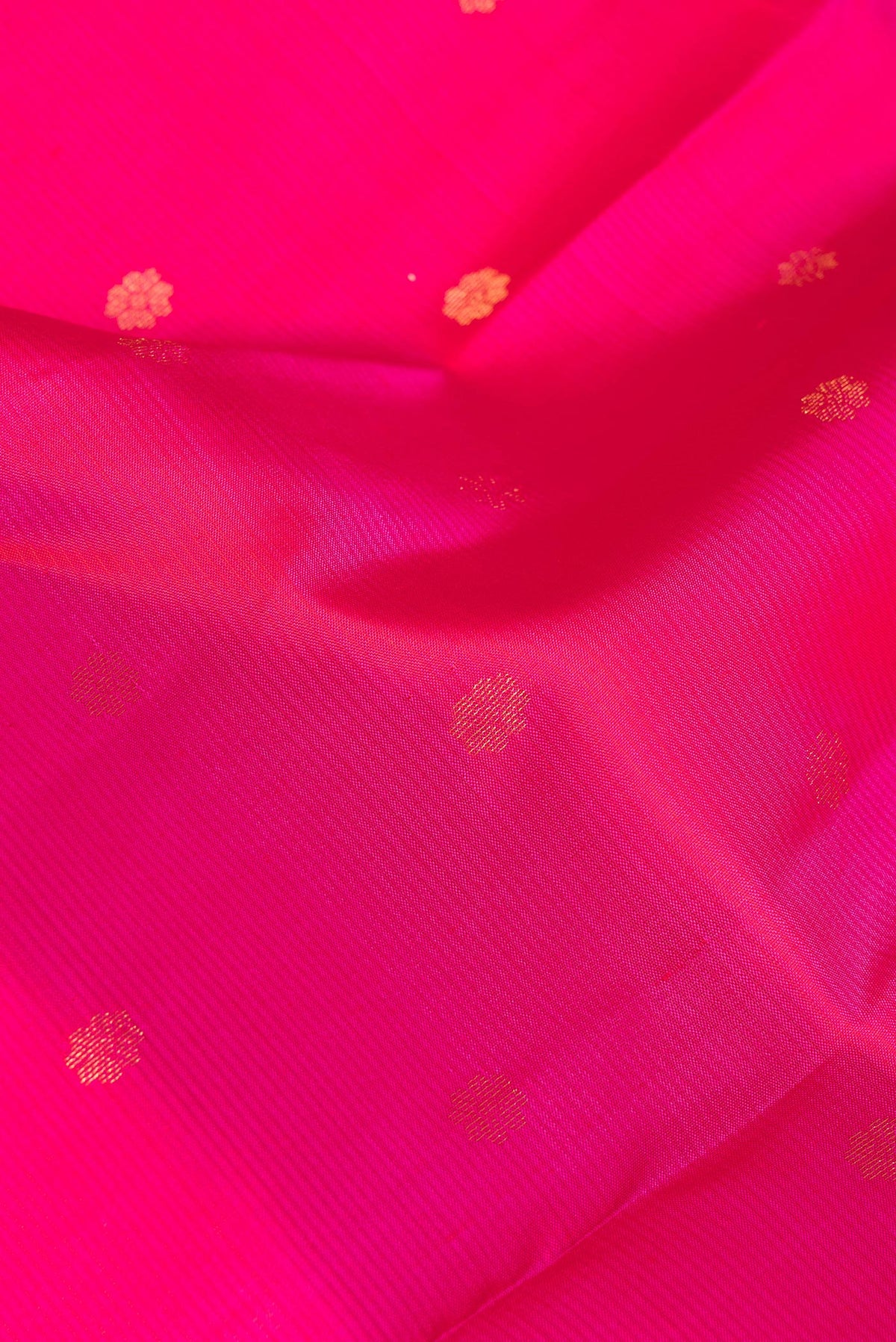 Close up of Pure Silk Dark Pink Kanchipuram Saree with Zari Butta on the body and Zari Border.  displaying folds