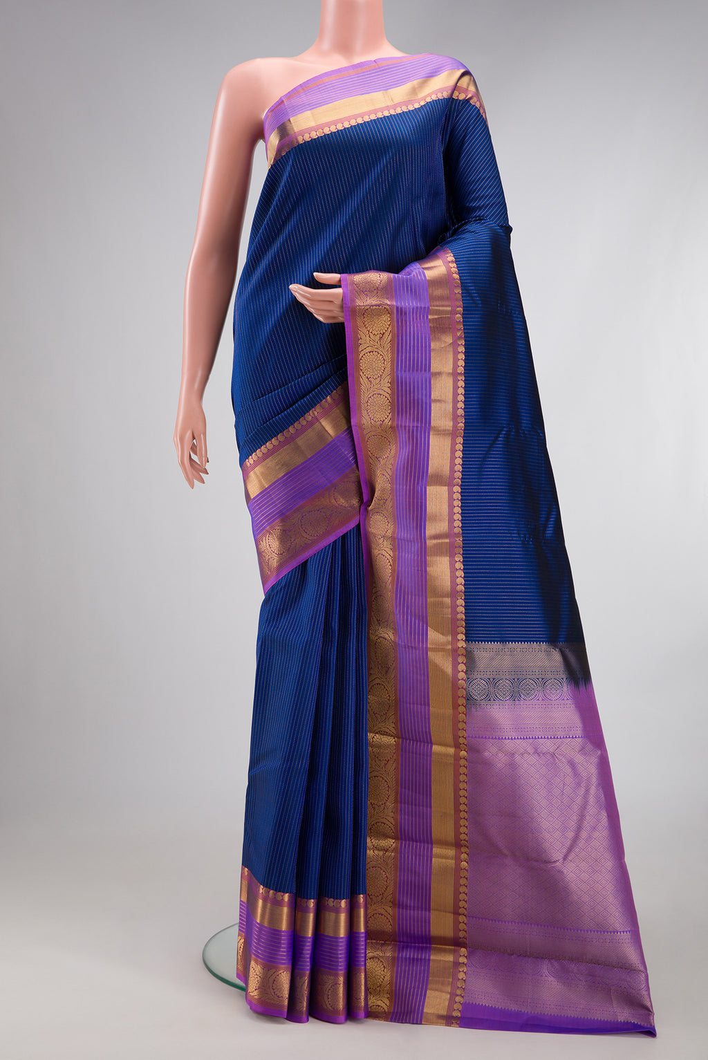 Navy Blue Dual Tone Kanjivaram Silk Saree with Stripes on the body and Fancy Border.  displayed on a mannequin