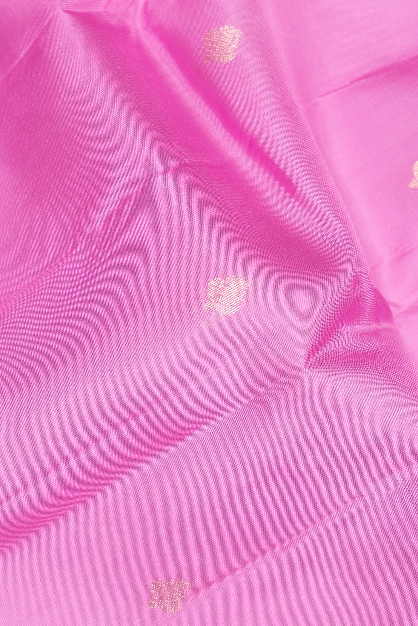 Close up of Pure Silk Rose pink Kanchipuram Saree with Zari Butta on the body and Zari Border.  displaying folds