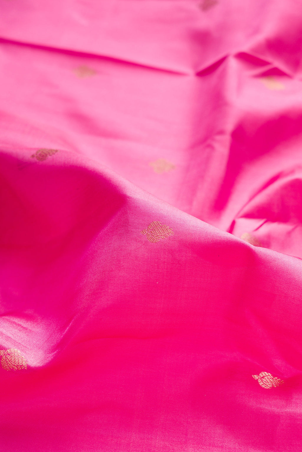 Close up of Pink Kanchipuram Silk Saree with Zari Butta on the body and Zari Border.  displaying folds