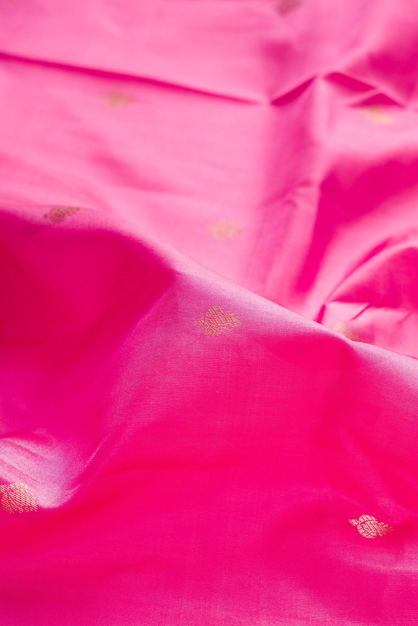 Close up of Pink Kanchipuram Silk Saree with Zari Butta on the body and Zari Border.  displaying folds
