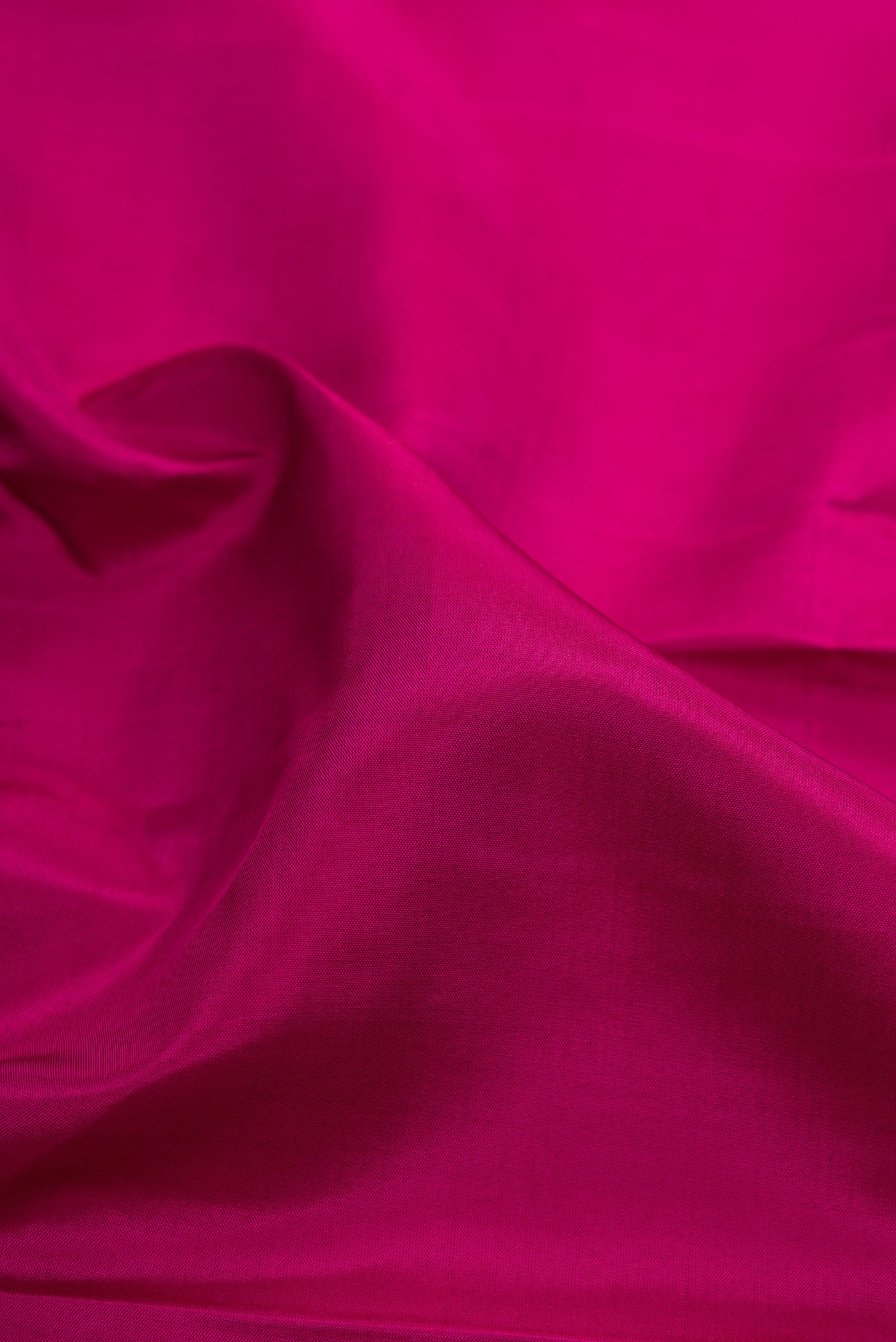 Close up of Magenta Kanchipuram Silk Saree with Plain Body and Fancy Border.  displaying folds