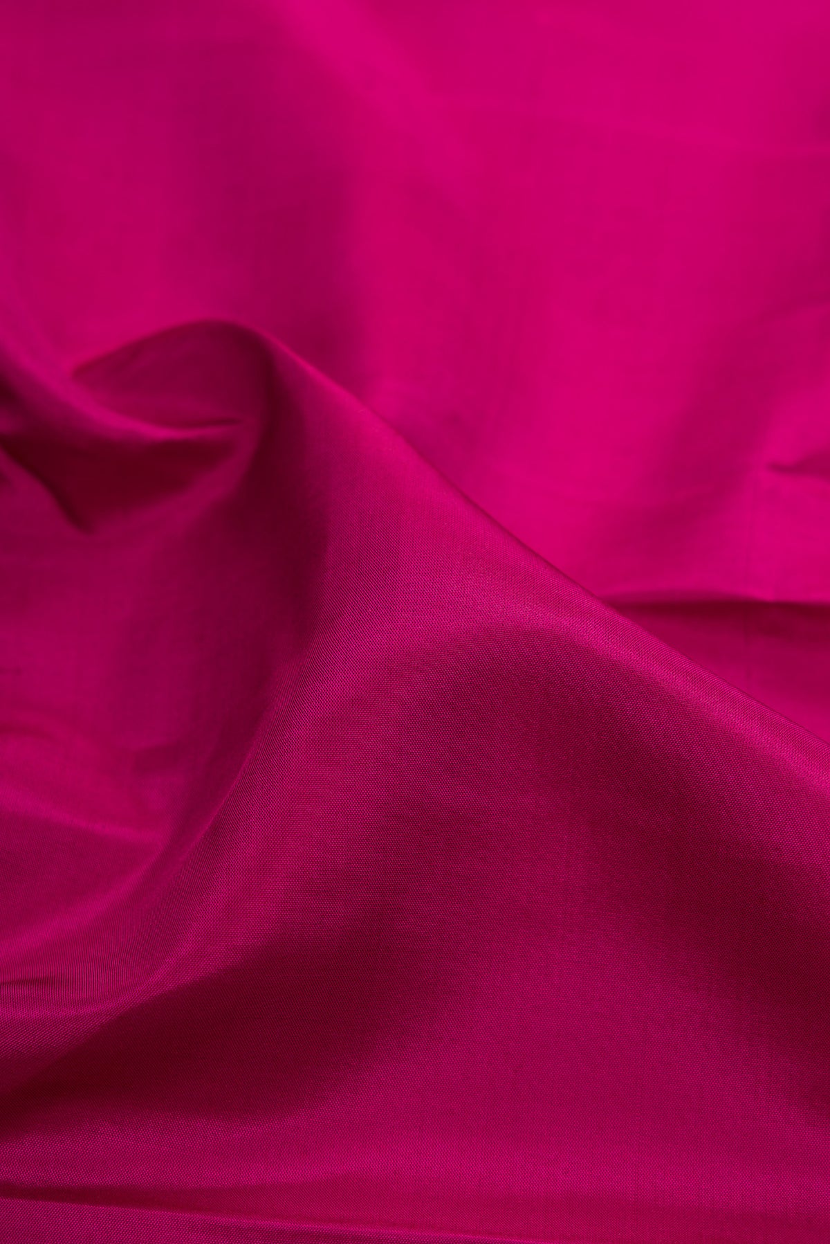 Close up of Magenta Kanchipuram Silk Saree with Plain Body and Fancy Border.  displaying folds