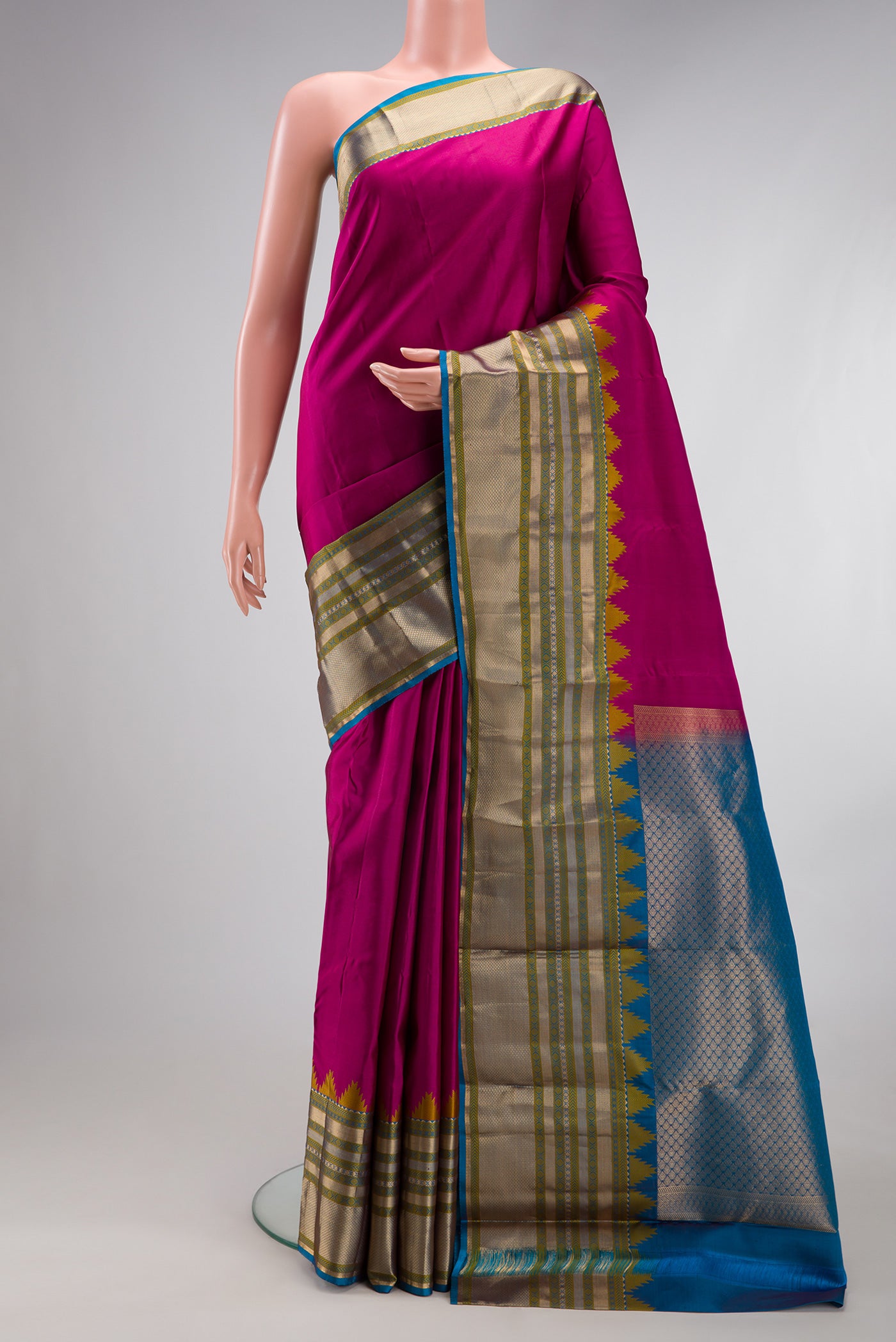 Magenta Kanchipuram Silk Saree with Plain Body and Fancy Border.  displayed on a mannequin