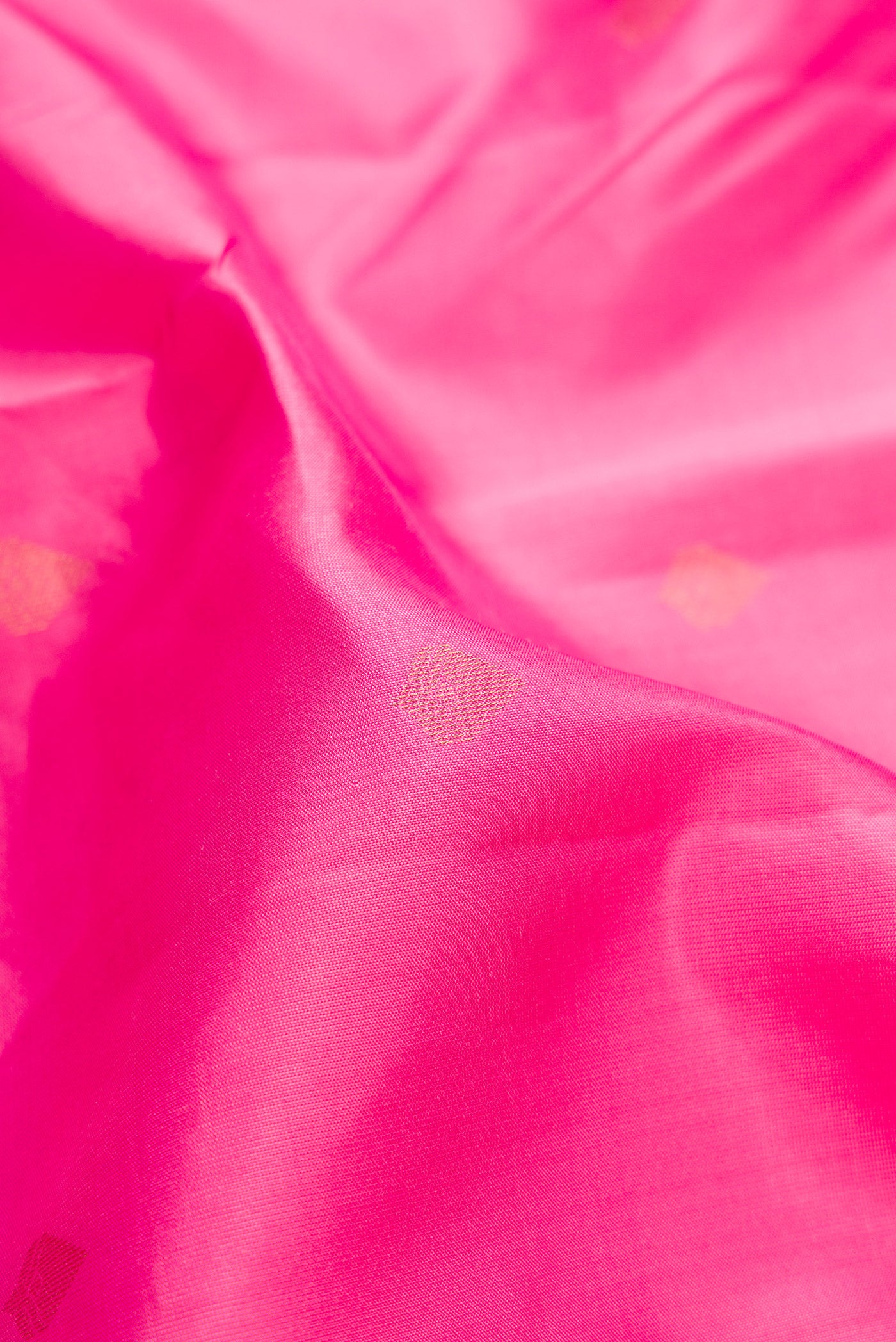 Close up of Rose pink Kanchipuram Silk Saree with Zari Butta on the body and Zari Border.  displaying folds
