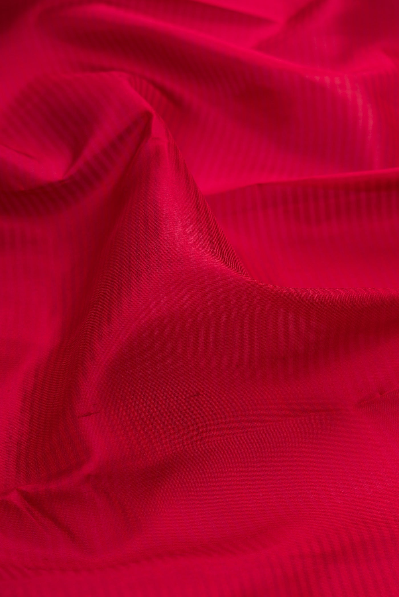 Close up of Maroon Kanchipuram Silk Saree with Stripes on the body and Zari Border.  displaying folds