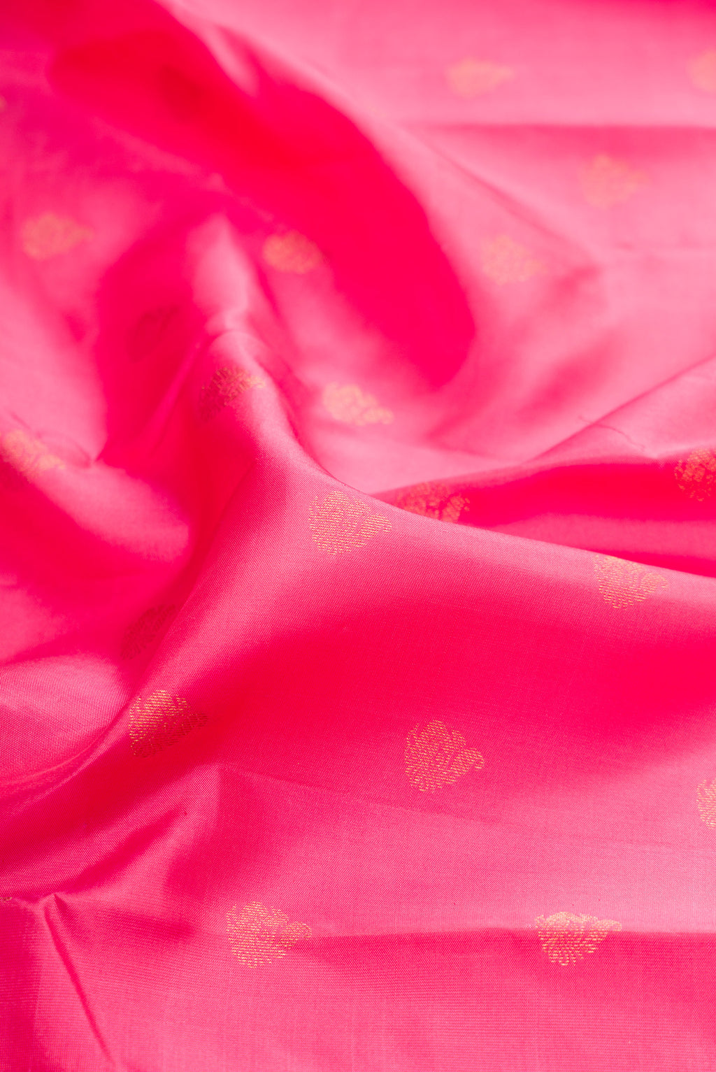 Close up of Rose pink Kanchipuram Silk Saree with Zari Butta on the body and Zari Border.  displaying folds