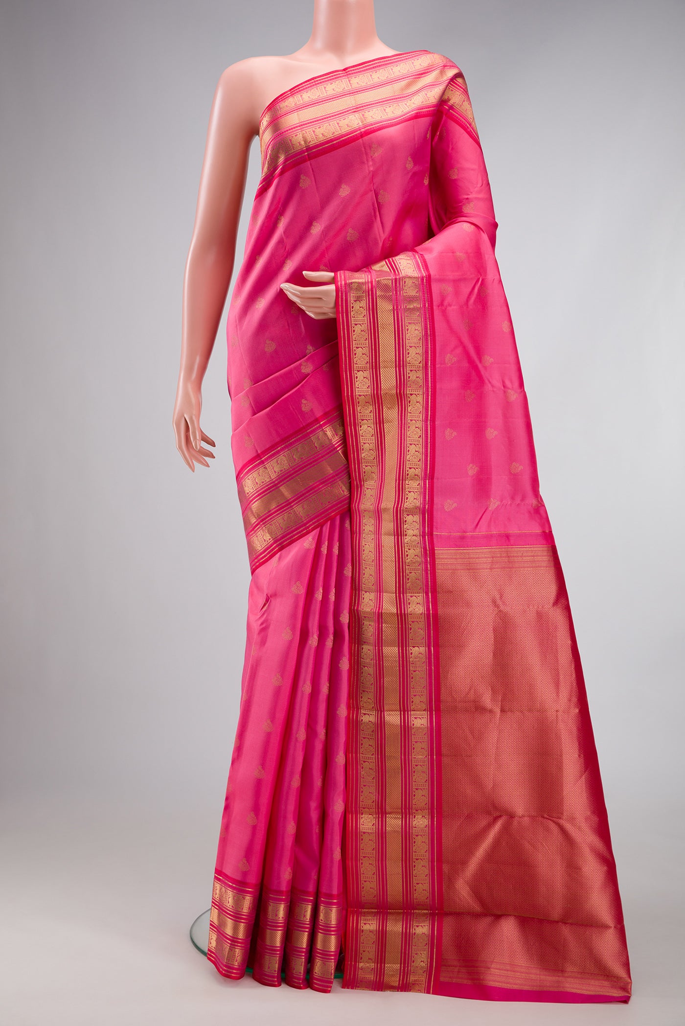 Rose pink Kanchipuram Silk Saree with Zari Butta on the body and Zari Border.  displayed on a mannequin