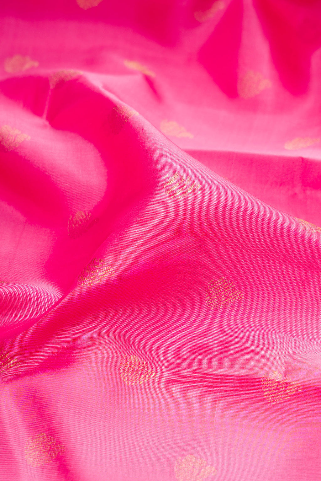 Close up of Pink Kanchipuram Silk Saree with Zari Butta on the body and Zari Border.  displaying folds