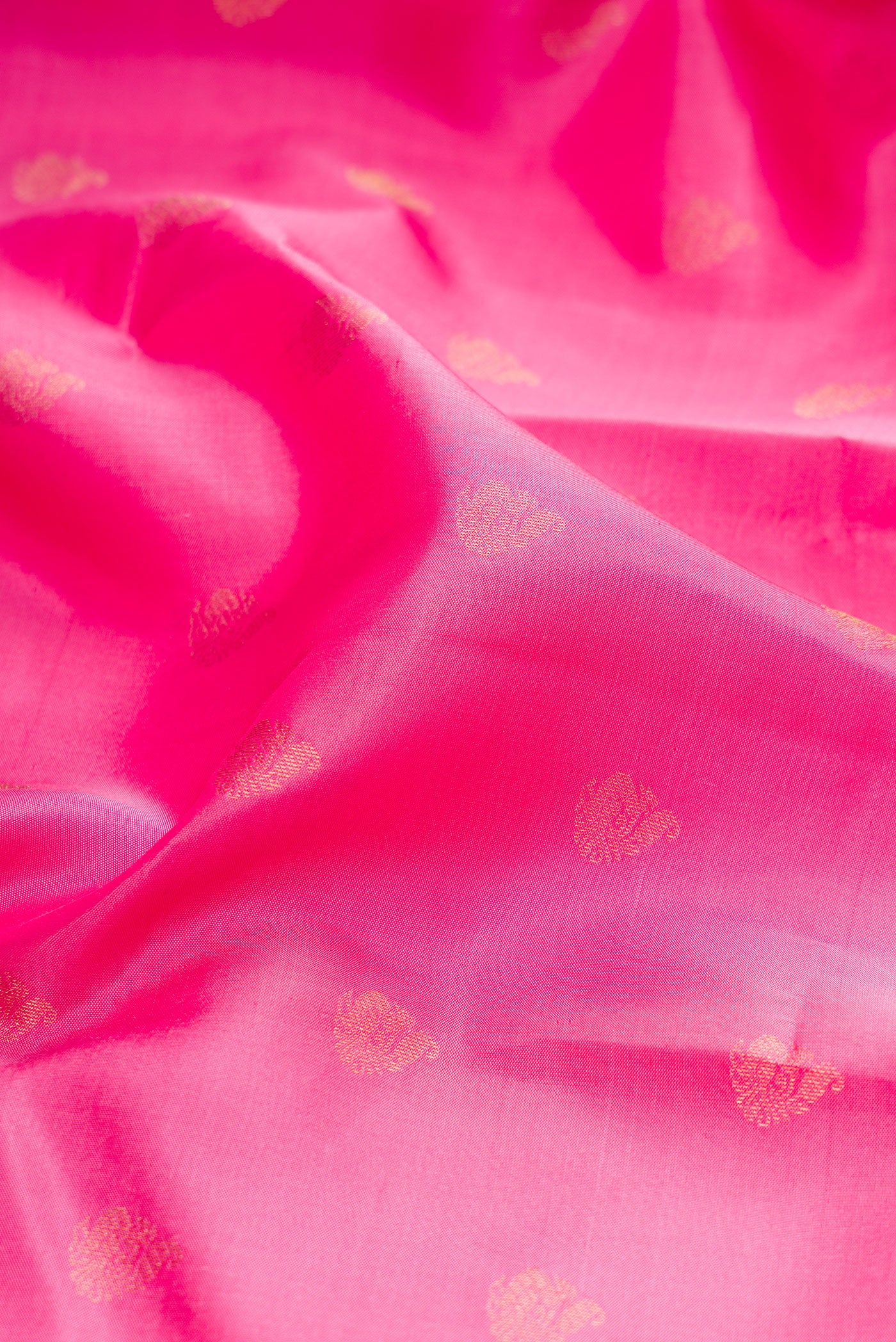Close up of Pink Kanchipuram Silk Saree with Zari Butta on the body and Zari Border.  displaying folds
