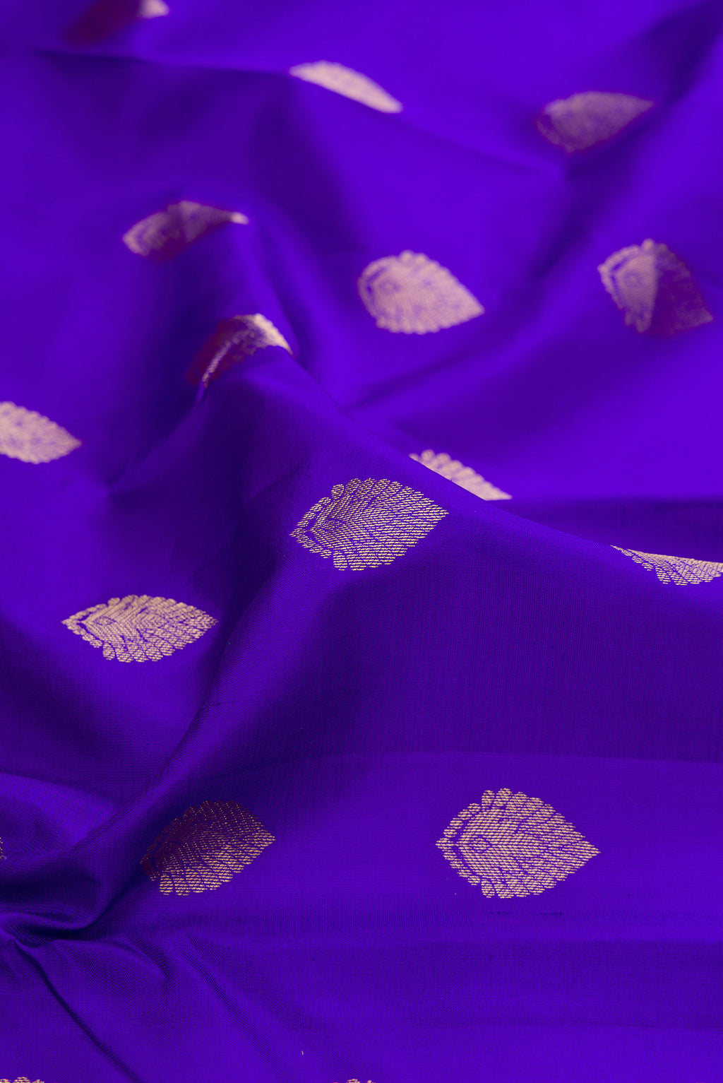 Close up of Royal Blue Kanchipuram Silk Saree with Zari Butta on the body and Zari Border.  displaying folds