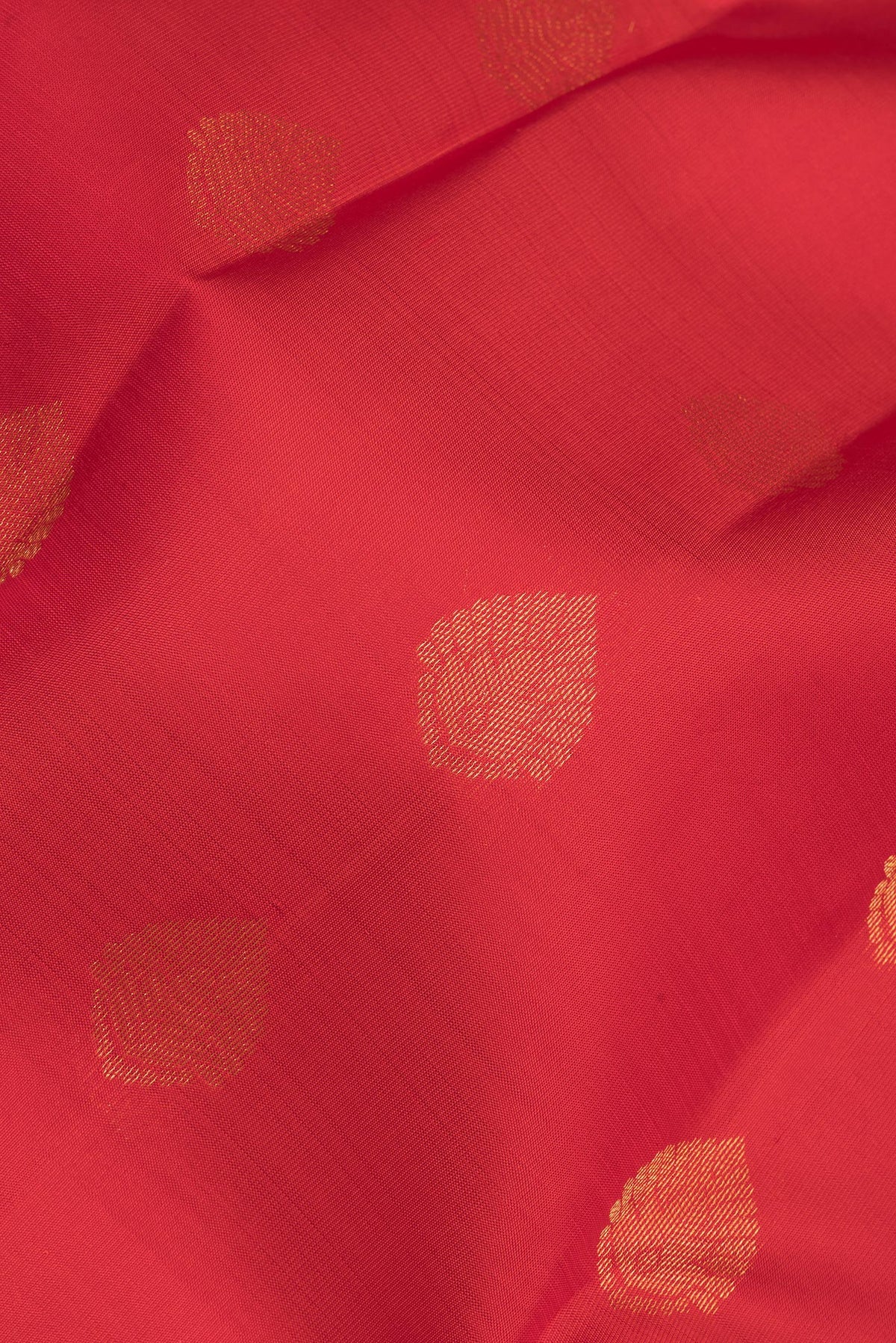 Close up of Pure Silk Red Kanchipuram Saree with Zari Butta on the body and Zari Border.  displaying folds