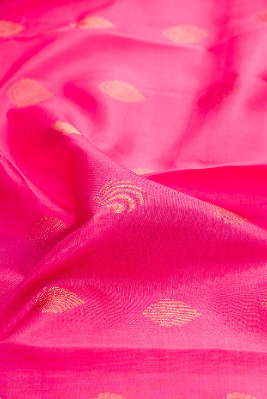 Close up of Pink Kanchipuram Silk Saree with Zari Butta on the body and Zari Border.  displaying folds