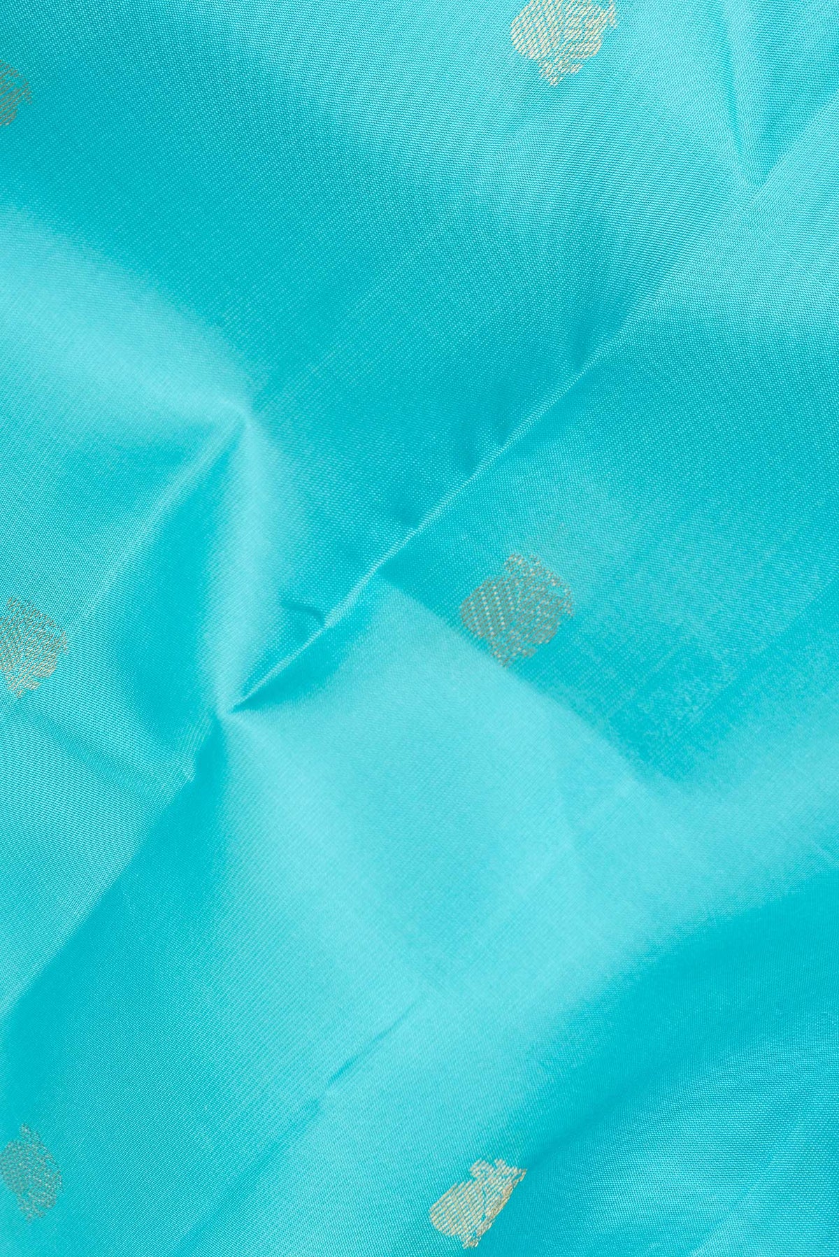 Close up of Pure Silk Sky Blue Kanchipuram Saree with Zari Butta on the body and Zari Border.  displaying folds