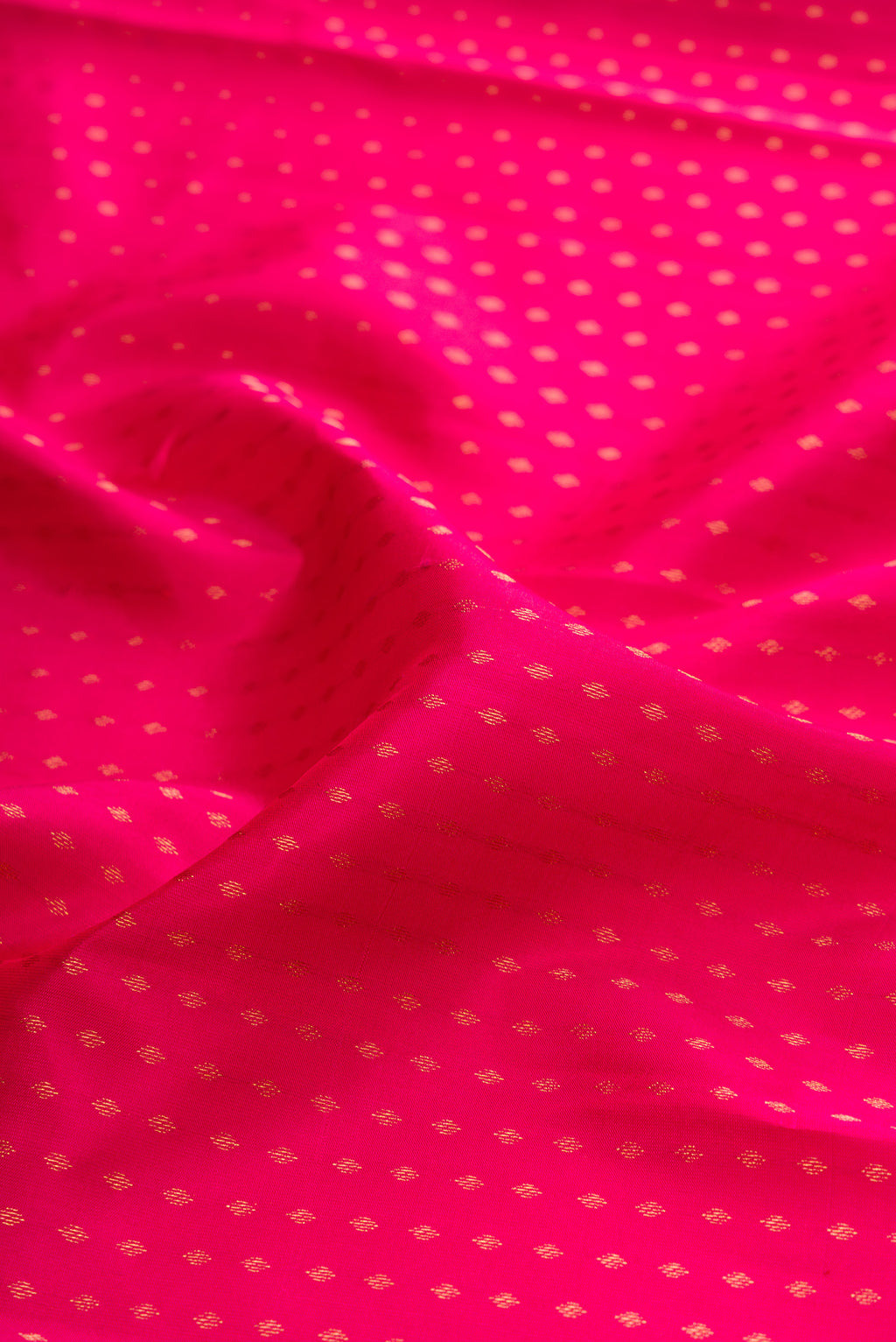 Close up of Pink Kanchipuram Silk Saree with Zari Butta on the body and Zari Border.  displaying folds