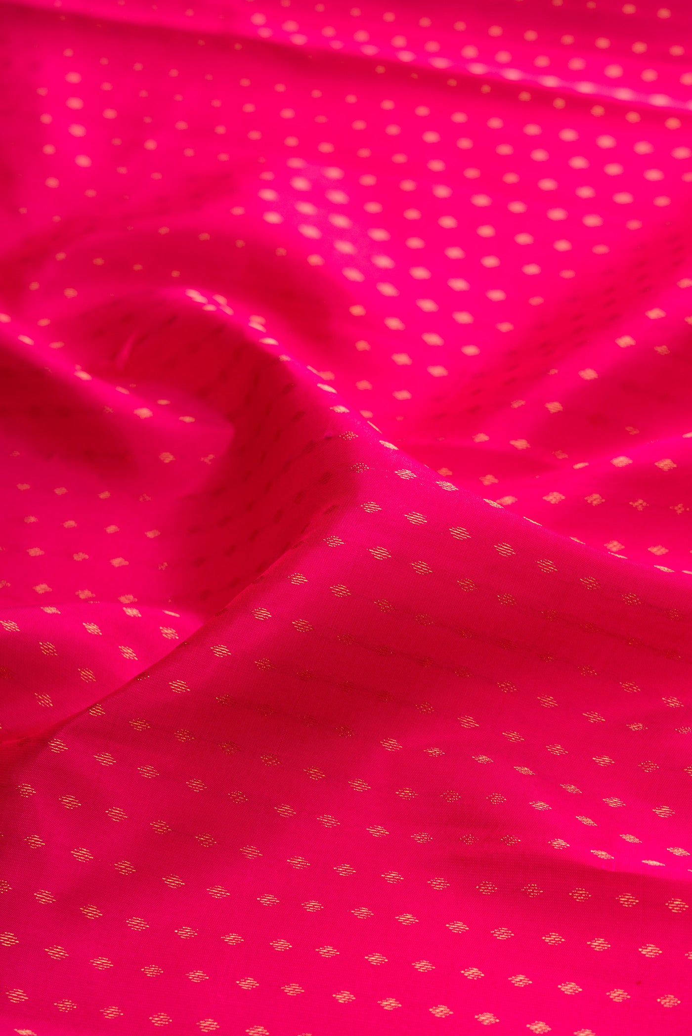 Close up of Pink Kanchipuram Silk Saree with Zari Butta on the body and Zari Border.  displaying folds