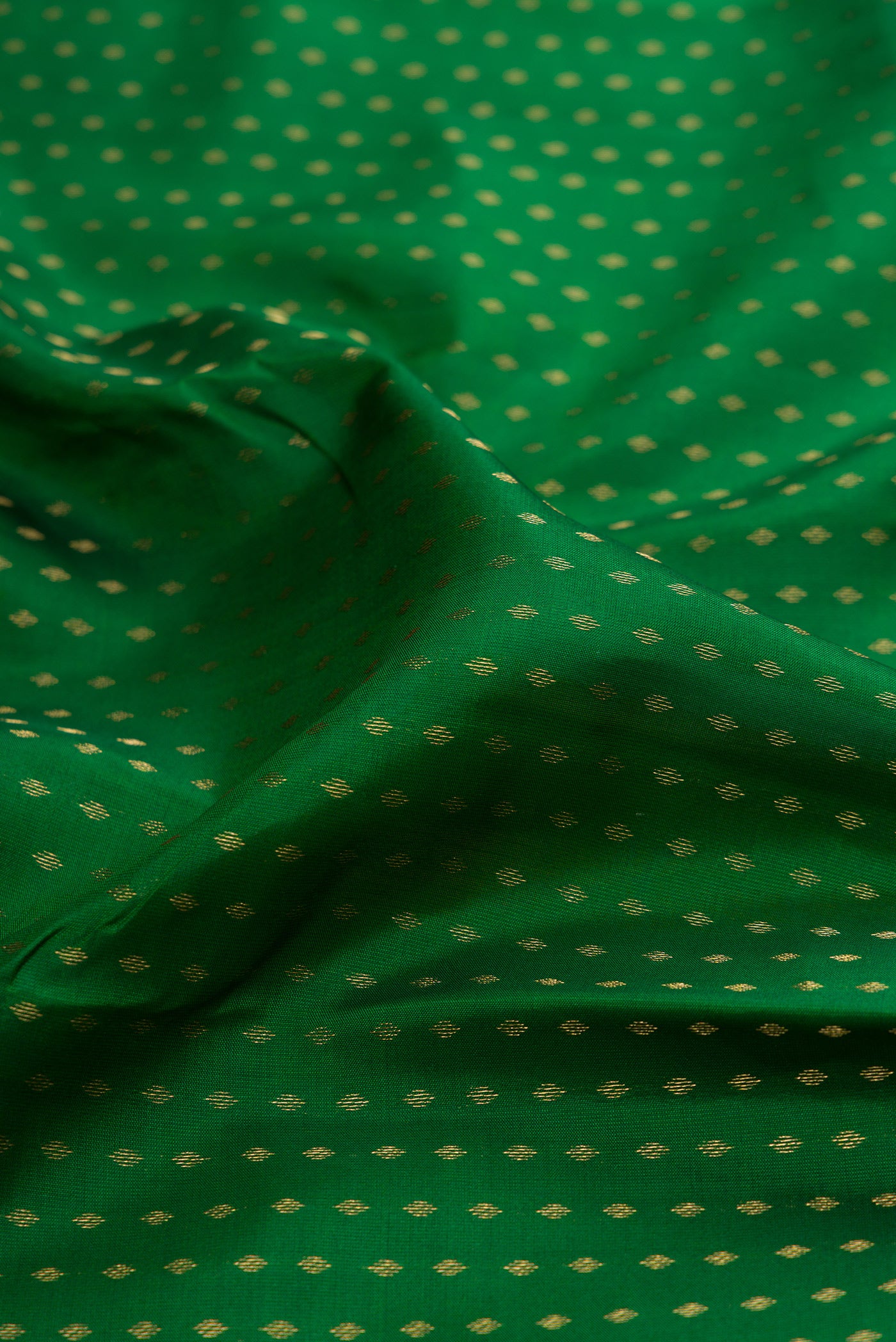 Close up of Green Kanchipuram Silk Saree with Zari Butta on the body and Zari Border.  displaying folds