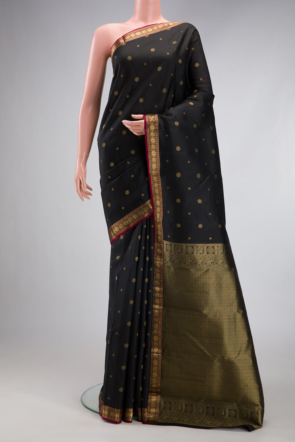 Black Kanchipuram Silk Saree with Zari Butta on the body and Zari Border.  displayed on a mannequin