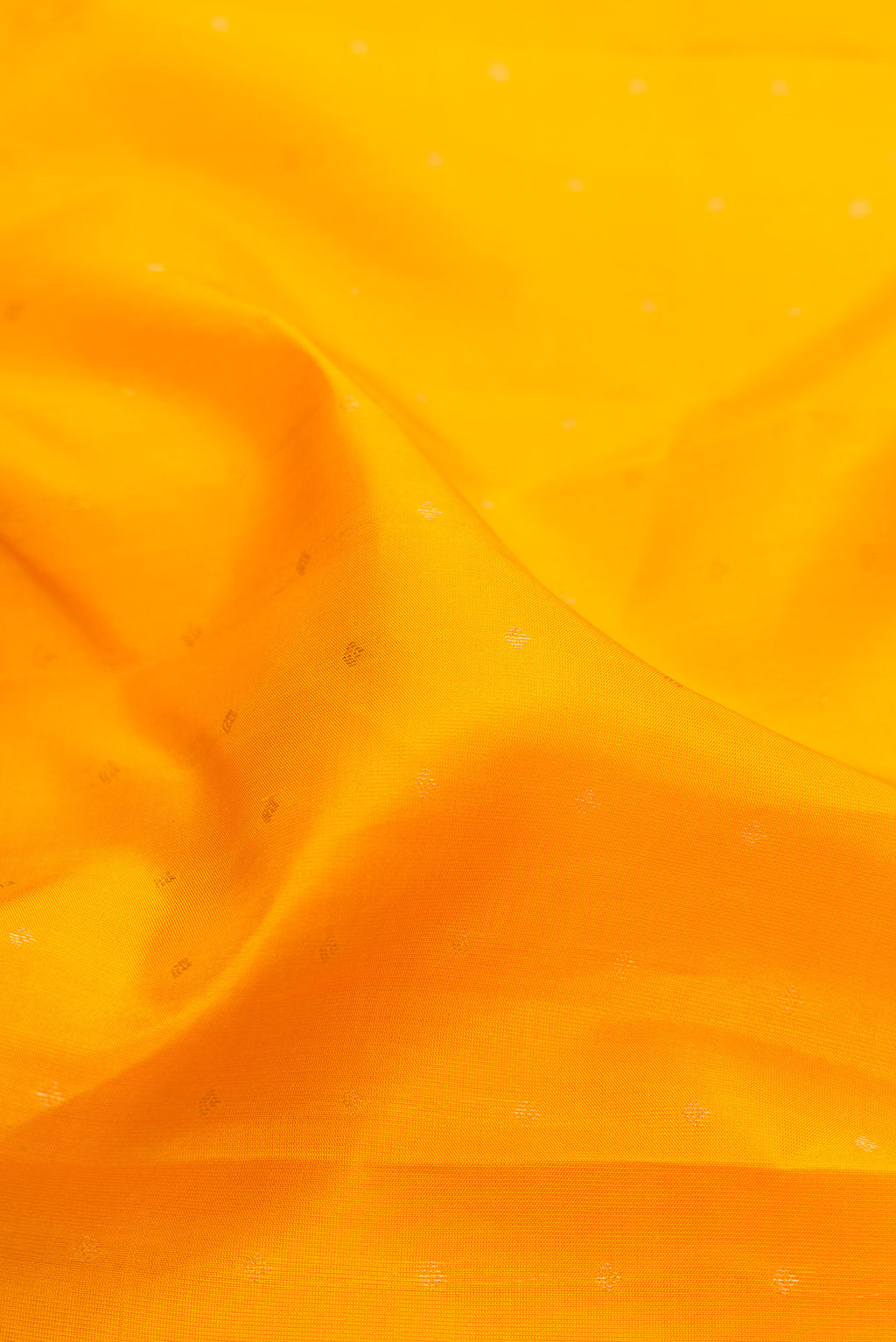 Close up of Yellow Kanchipuram Silk Saree with Zari Butta on the body and Fancy Border.  displaying folds