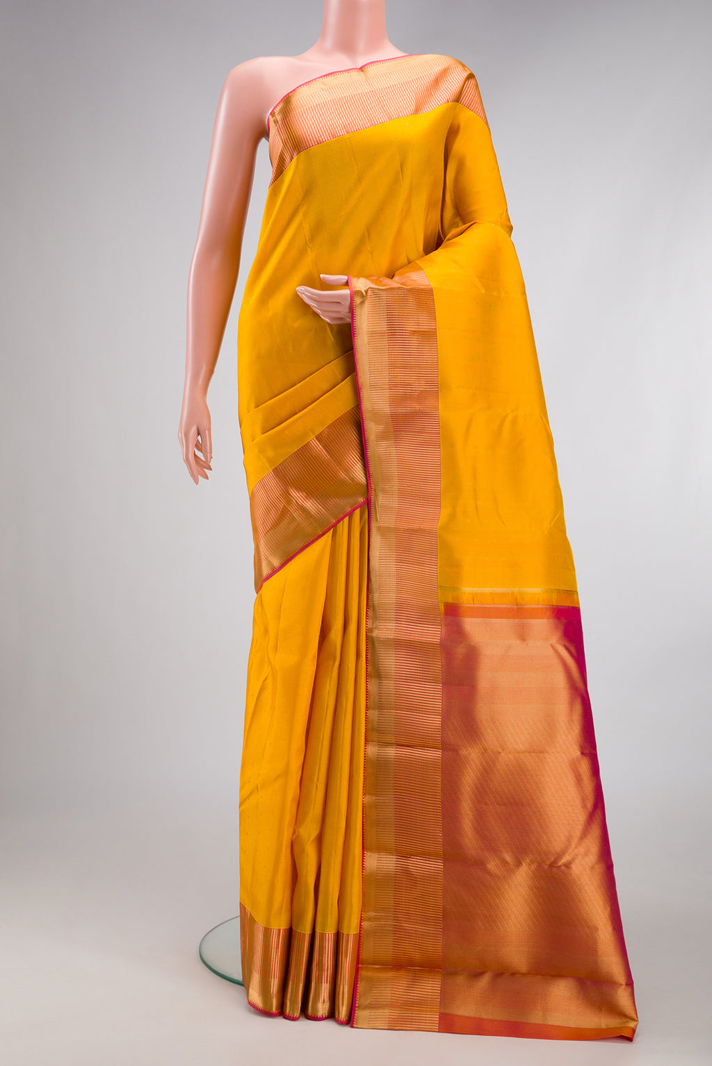 Yellow Kanchipuram Silk Saree with Zari Butta on the body and Fancy Border.  displayed on a mannequin