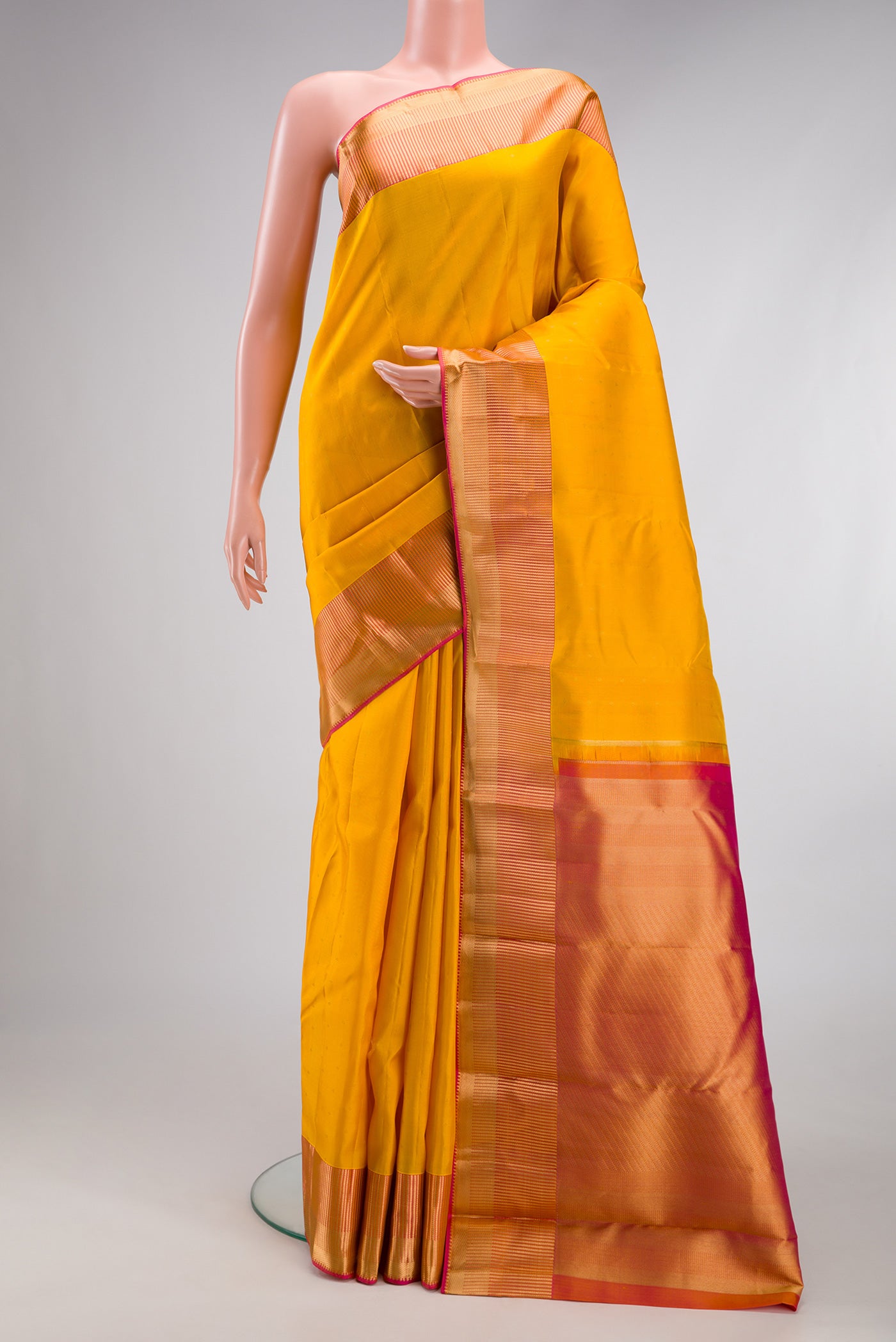 Yellow Kanchipuram Silk Saree with Zari Butta on the body and Fancy Border.  displayed on a mannequin