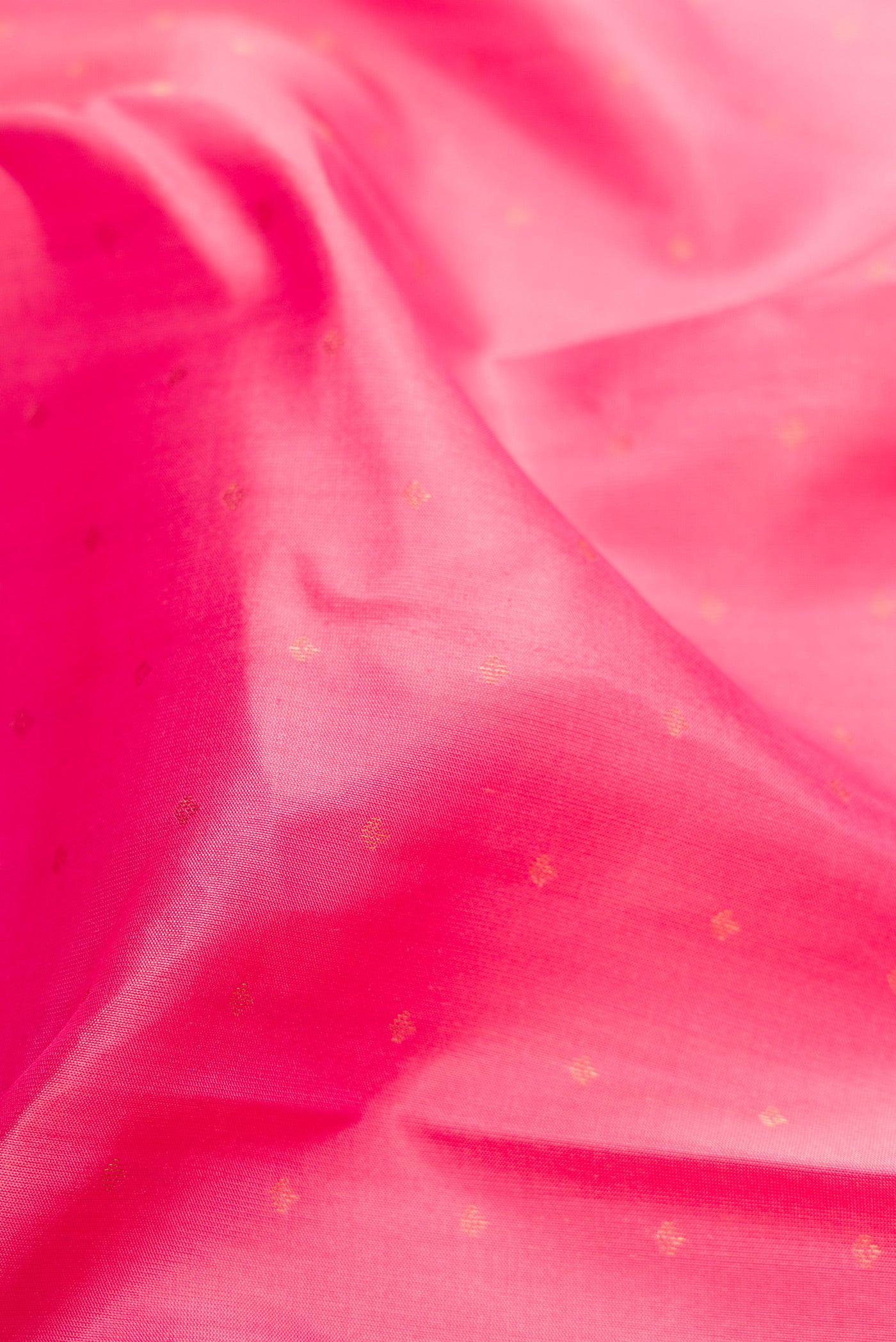 Close up of Pink Kanchipuram Silk Saree with Zari Butta on the body and Zari Border.  displaying folds