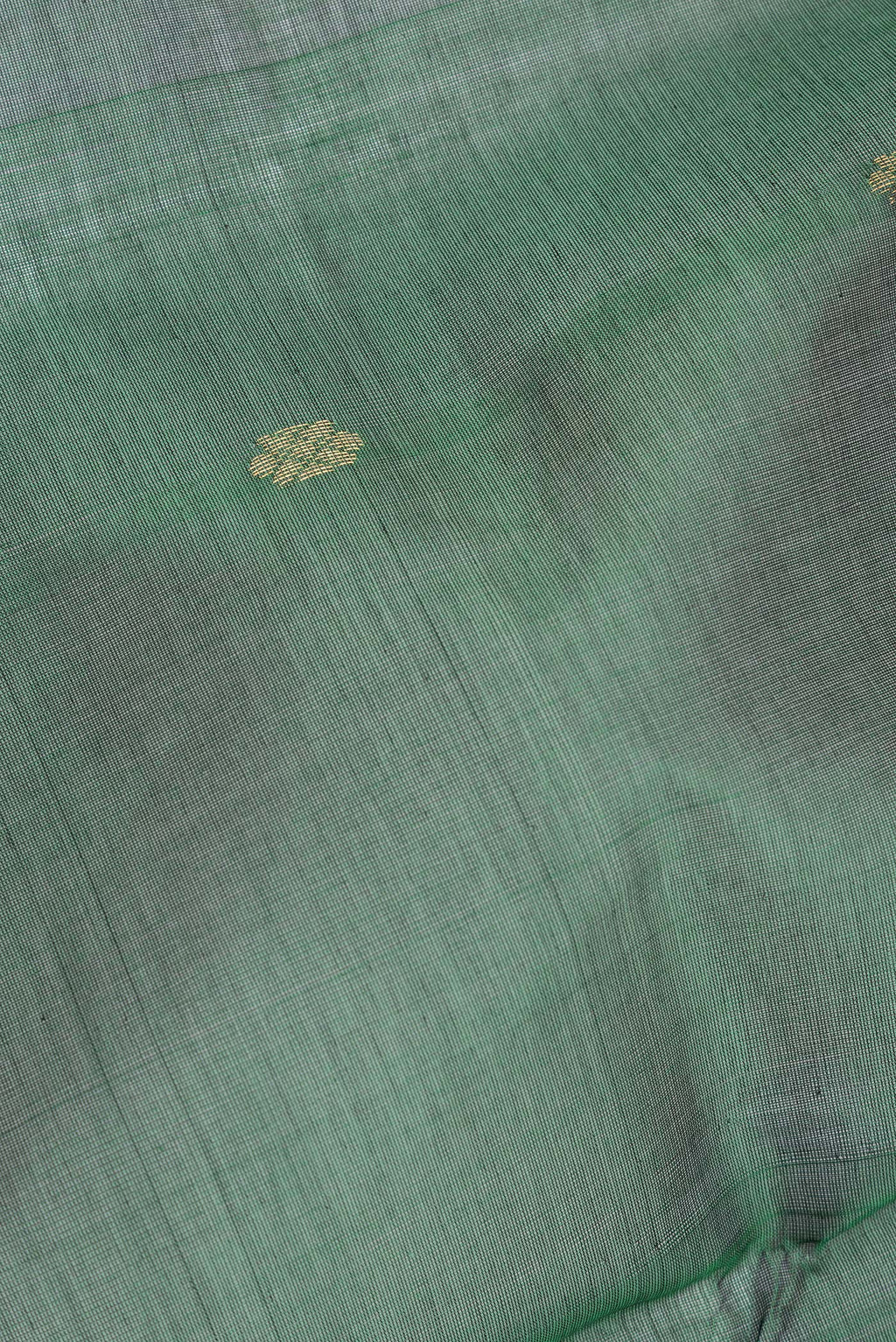 Close up of Bottle Green Silk Cotton Saree with Zari Butta on the body and Zari Border.  displaying folds