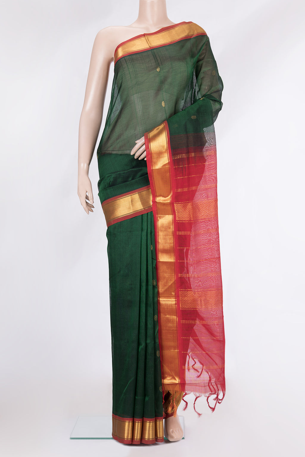 Bottle Green Silk Cotton Saree with Zari Butta on the body and Zari Border.  displayed on a mannequin