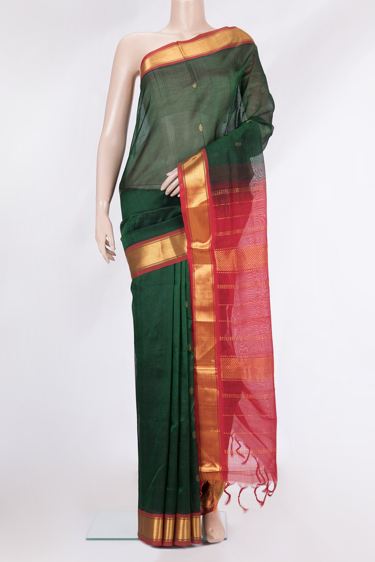 Bottle Green Silk Cotton Saree with Zari Butta on the body and Zari Border.  displayed on a mannequin