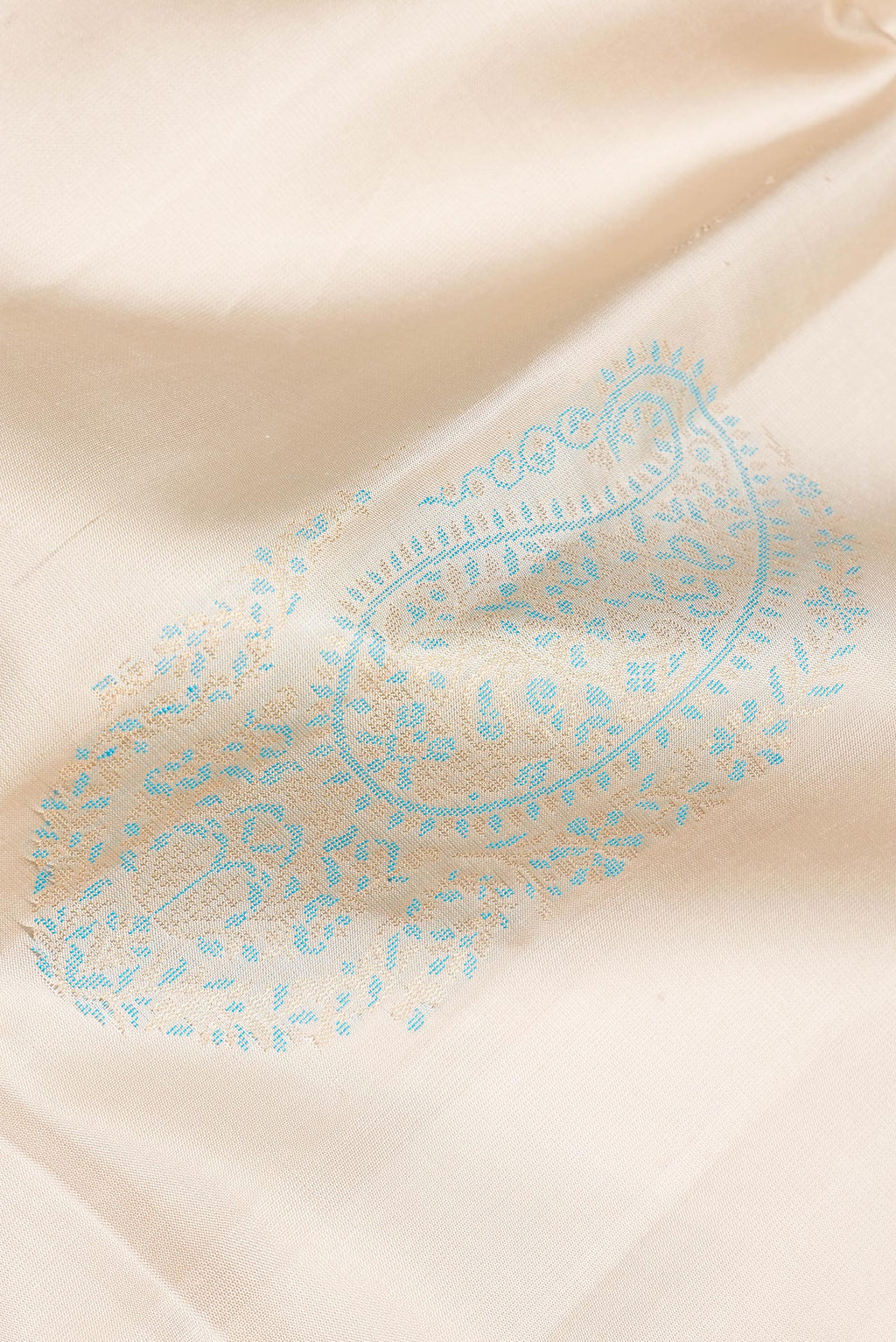 Close up of Pure Silk Beige Soft Saree with Zari And Thread Butta on the body and Zari Border.  displaying folds