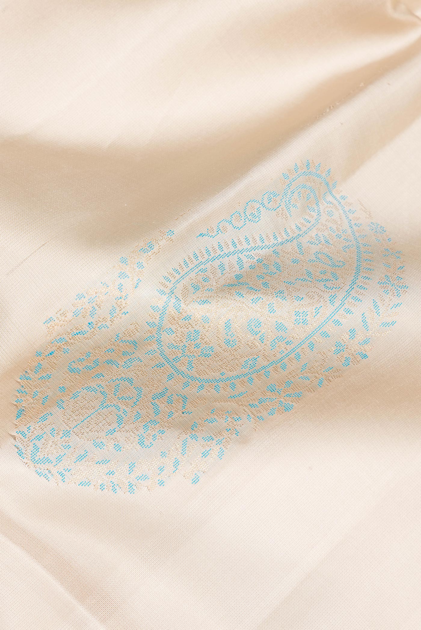 Close up of Pure Silk Beige Soft Saree with Zari And Thread Butta on the body and Zari Border.  displaying folds
