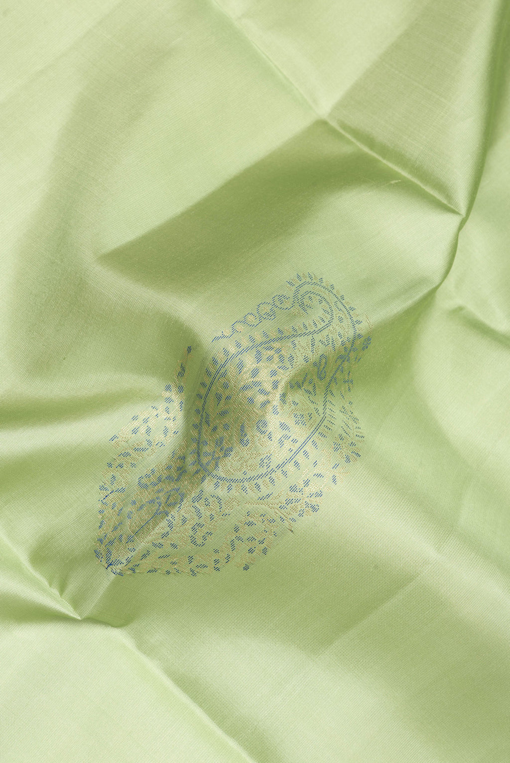 Close up of Pure Silk Pista Green Soft Saree with Zari Butta on the body and Zari Border.  displaying folds