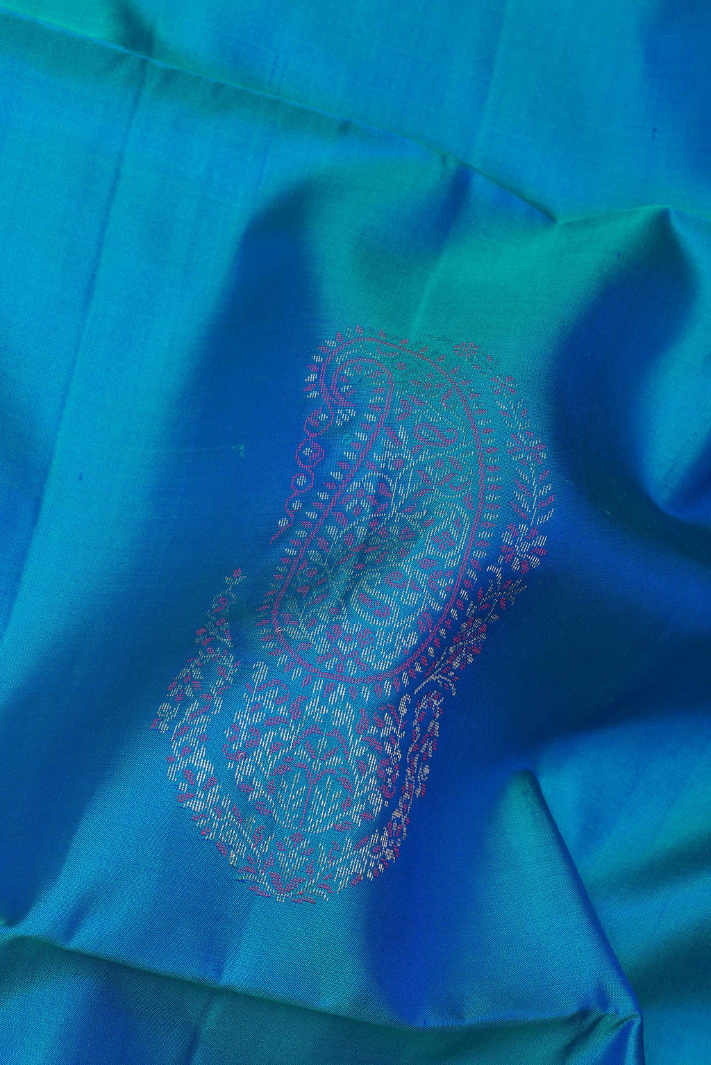 Close up of Pure Silk Peacock Blue Soft Saree with Zari Butta on the body and Zari Border.  displaying folds