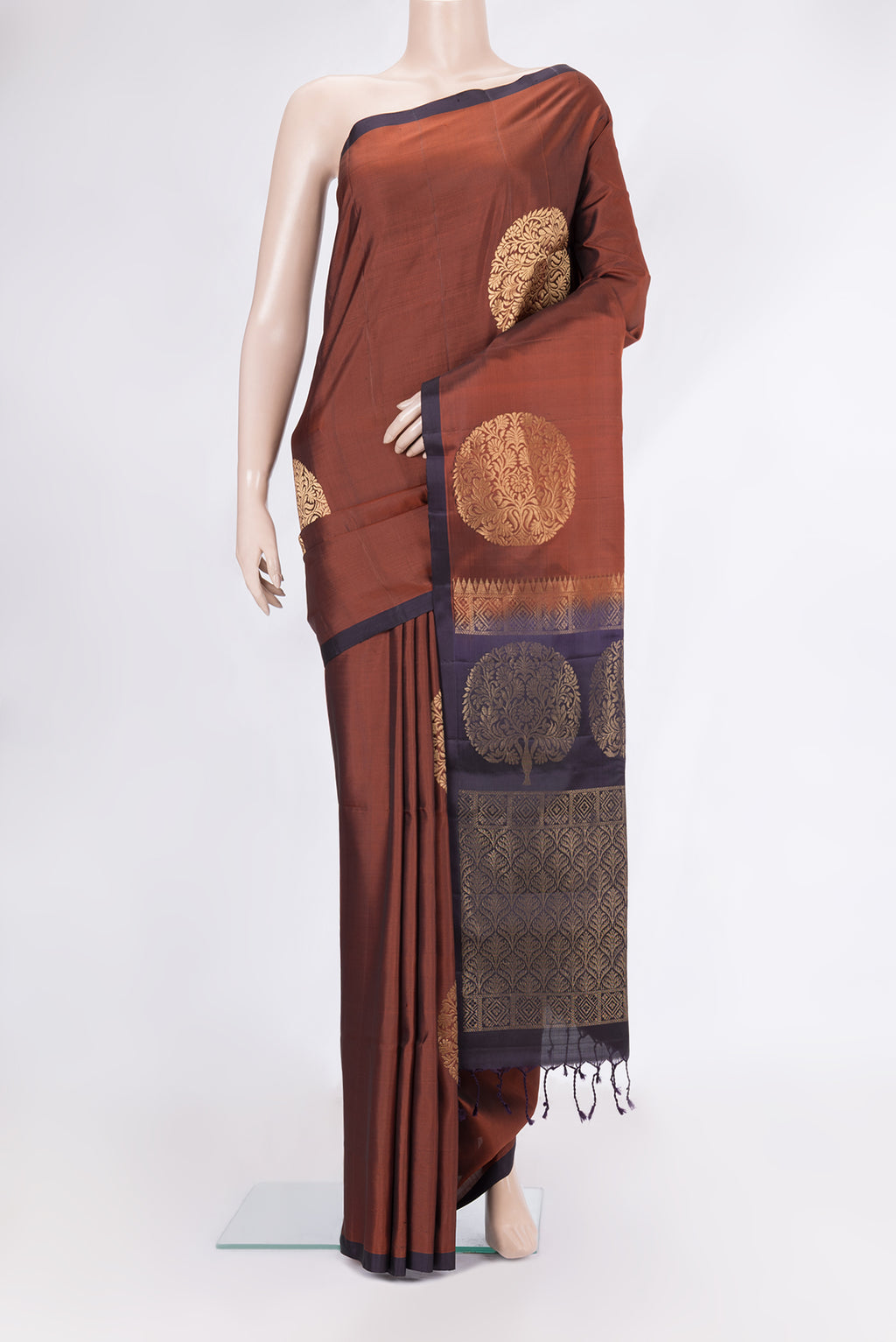 Rust Soft Silk Saree with Zari Butta on the body and Without Border.  displayed on a mannequin