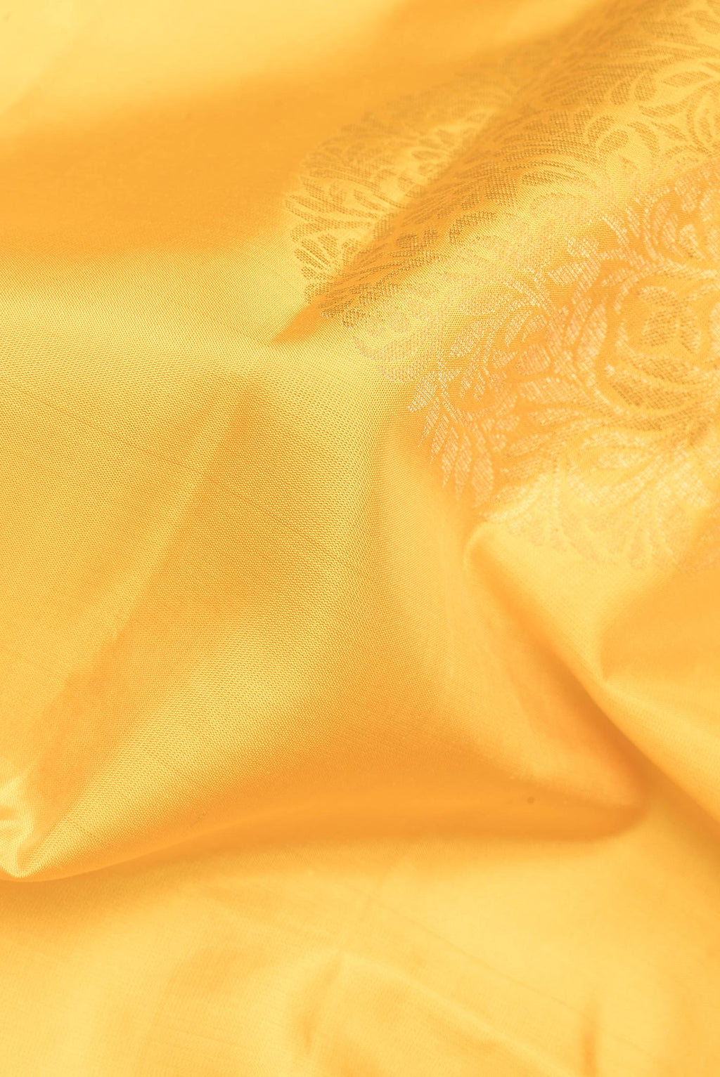 Close up of Pure Silk Yellow Soft Saree with Zari Butta on the body and Plain Border.  displaying folds