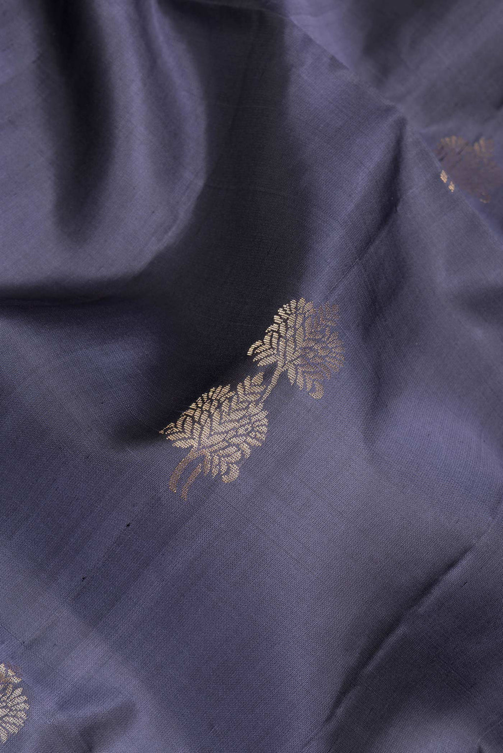 Close up of Grey Soft Silk Saree with Zari Butta on the body and Zari Border.  displaying folds