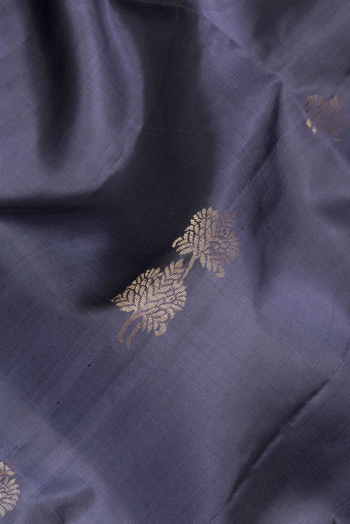 Close up of Grey Soft Silk Saree with Zari Butta on the body and Zari Border.  displaying folds