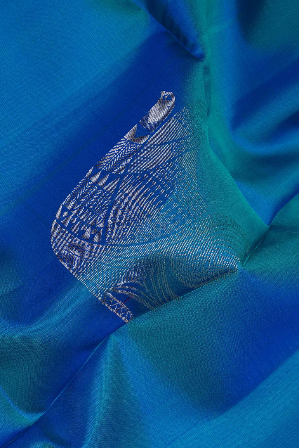 Close up of Pure Silk Peacock Blue Soft Saree with Zari Butta on the body and Zari Border.  displaying folds